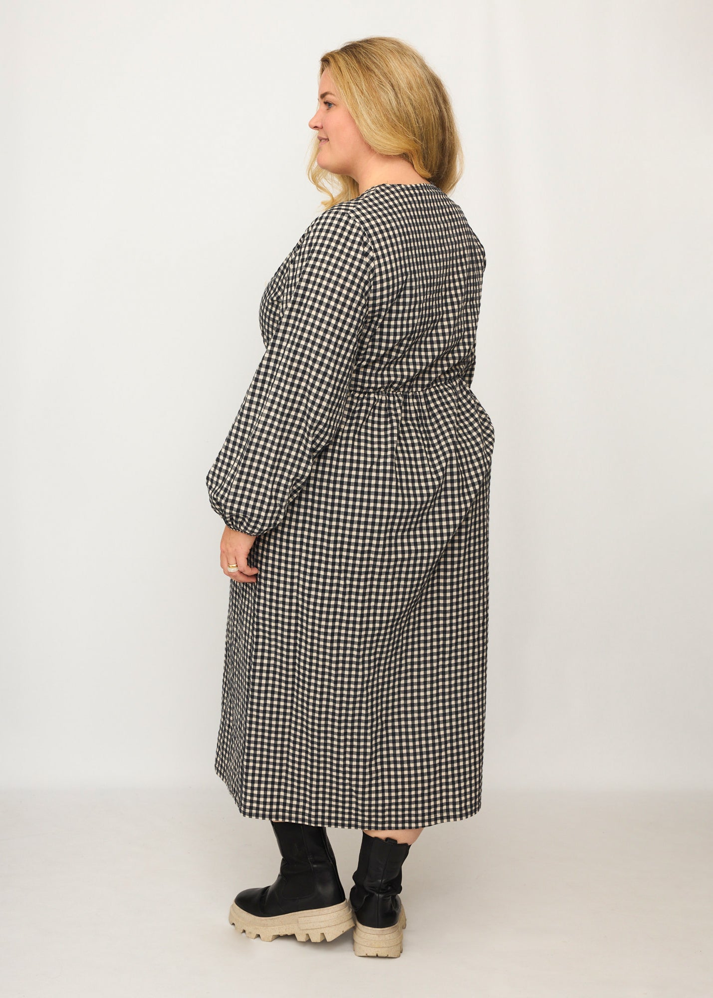 Nina trägt auf dem Foto 'Belinda', Ballonärmel, hohe Taille 5cm weiter unten, Größe 4XL +14 cm am Saum, Seersucker schwarz-creme
