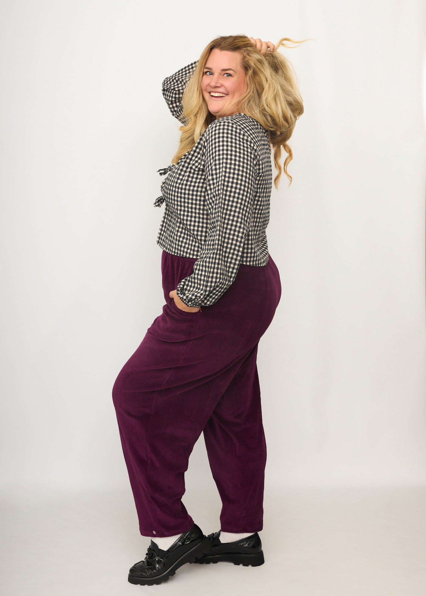 Nina trägt auf dem Foto 'Betty' Größe XXXL, Velvet-Cord aubergine und 'Bella' mit Ballonärmel Größe XXXL, Seersucker schwarz-creme