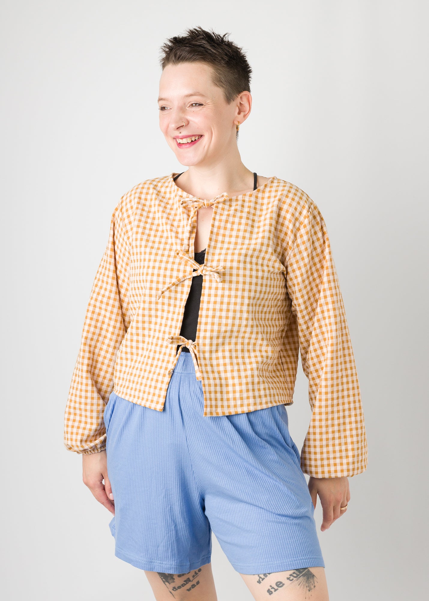 Melly trägt auf dem Foto 'Bella' mit 3 Bändern Größe S, Seersucker und 'Kira' Größe M, Rippjersey