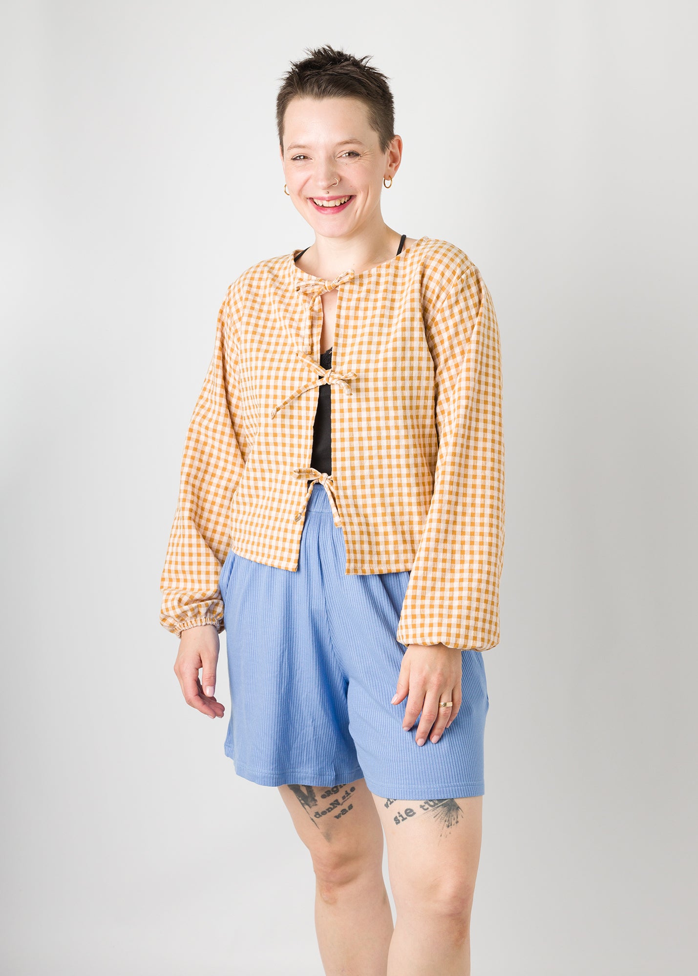 Melly trägt auf dem Foto 'Bella' mit 3 Bändern, Ballonärmel, Größe S, Seersucker senfgelb-creme und 'Kira' Größe M, Rippjersey babyblau