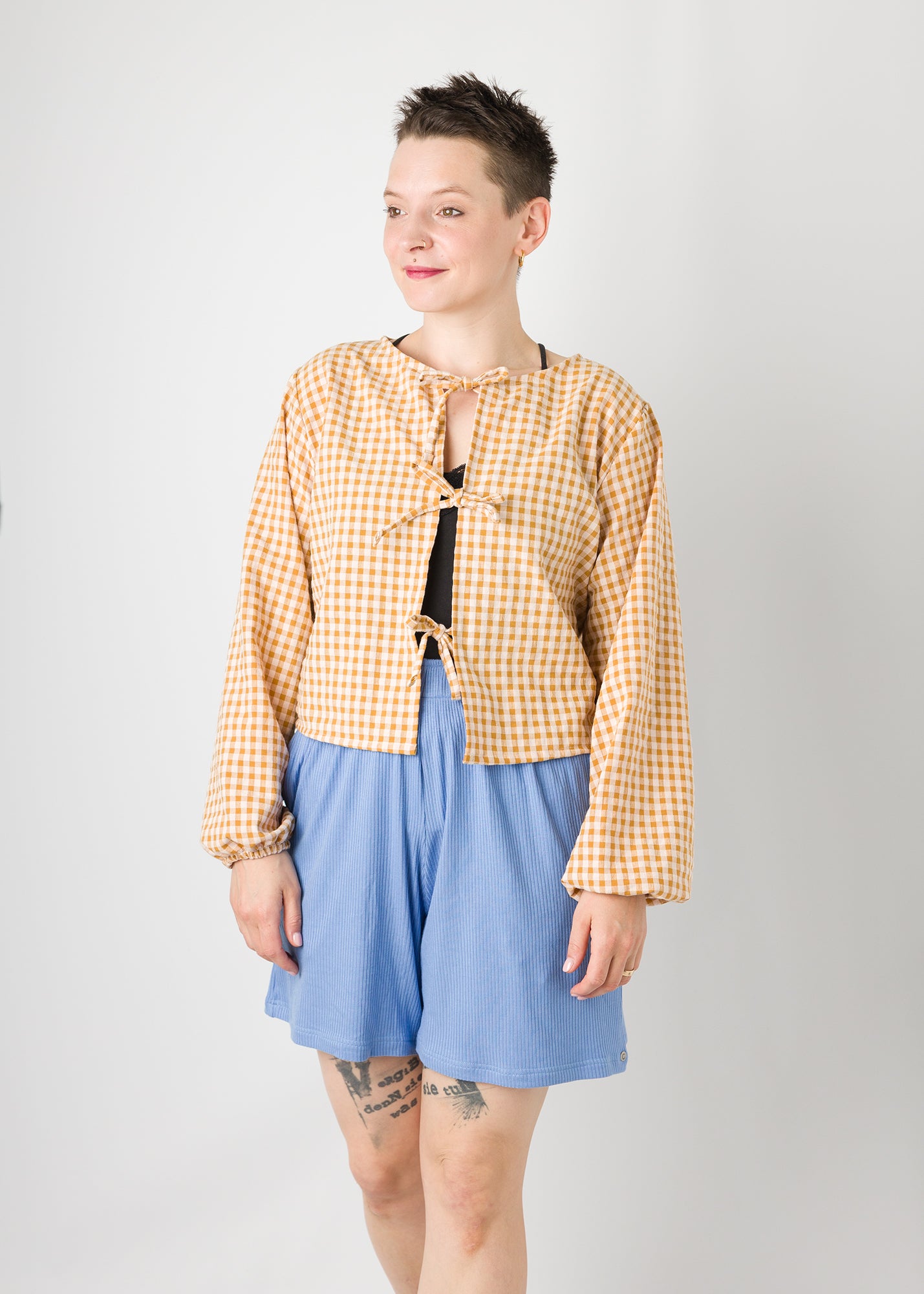 Melly trägt auf dem Foto 'Bella' mit 3 Bändern, Ballonärmel, Größe S, Seersucker senfgelb-creme und 'Kira' Größe M, Rippjersey babyblau