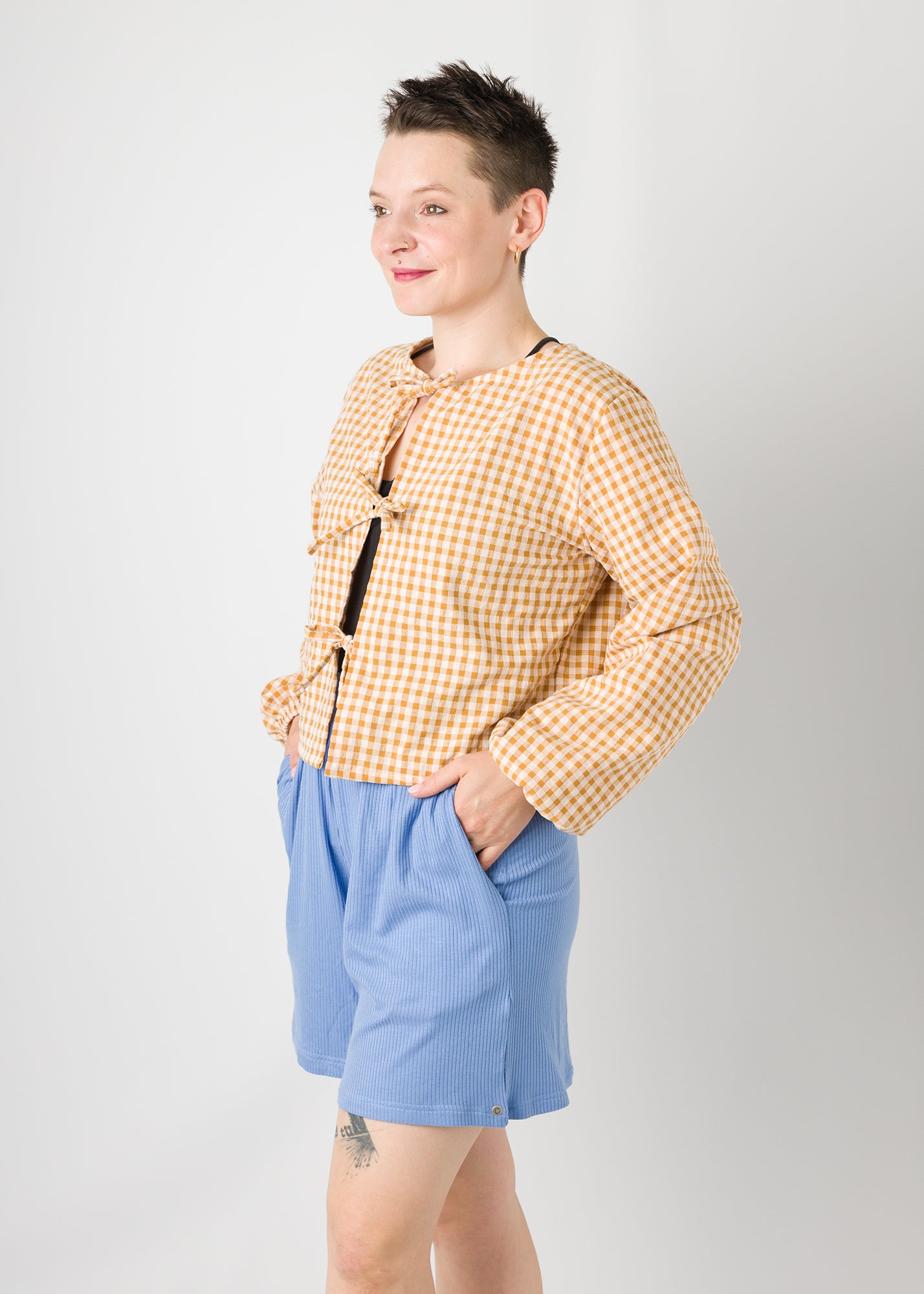 Melly trägt auf dem Foto 'Bella' mit 3 Bändern, Ballonärmel, Größe S, Seersucker senfgelb-creme und 'Kira' Größe M, Rippjersey babyblau