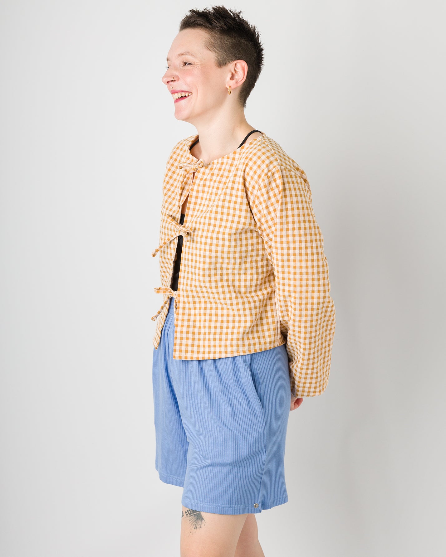 Melly trägt auf dem Foto 'Bella' mit 3 Bändern Größe S, Seersucker und 'Kira' Größe M, Rippjersey