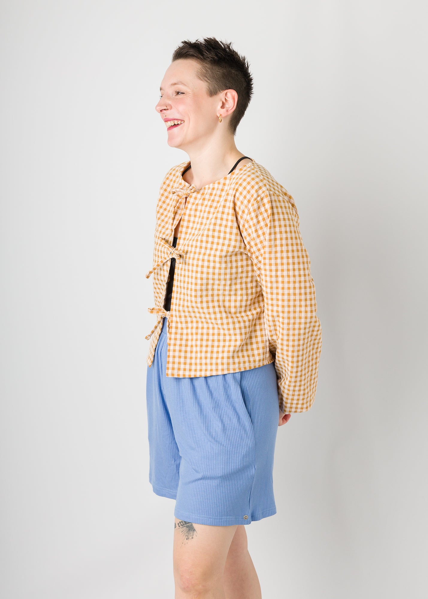 Melly trägt auf dem Foto 'Bella' mit 3 Bändern Größe S, Seersucker senfgelb-creme und 'Kira' Größe M, Rippjersey babyblau