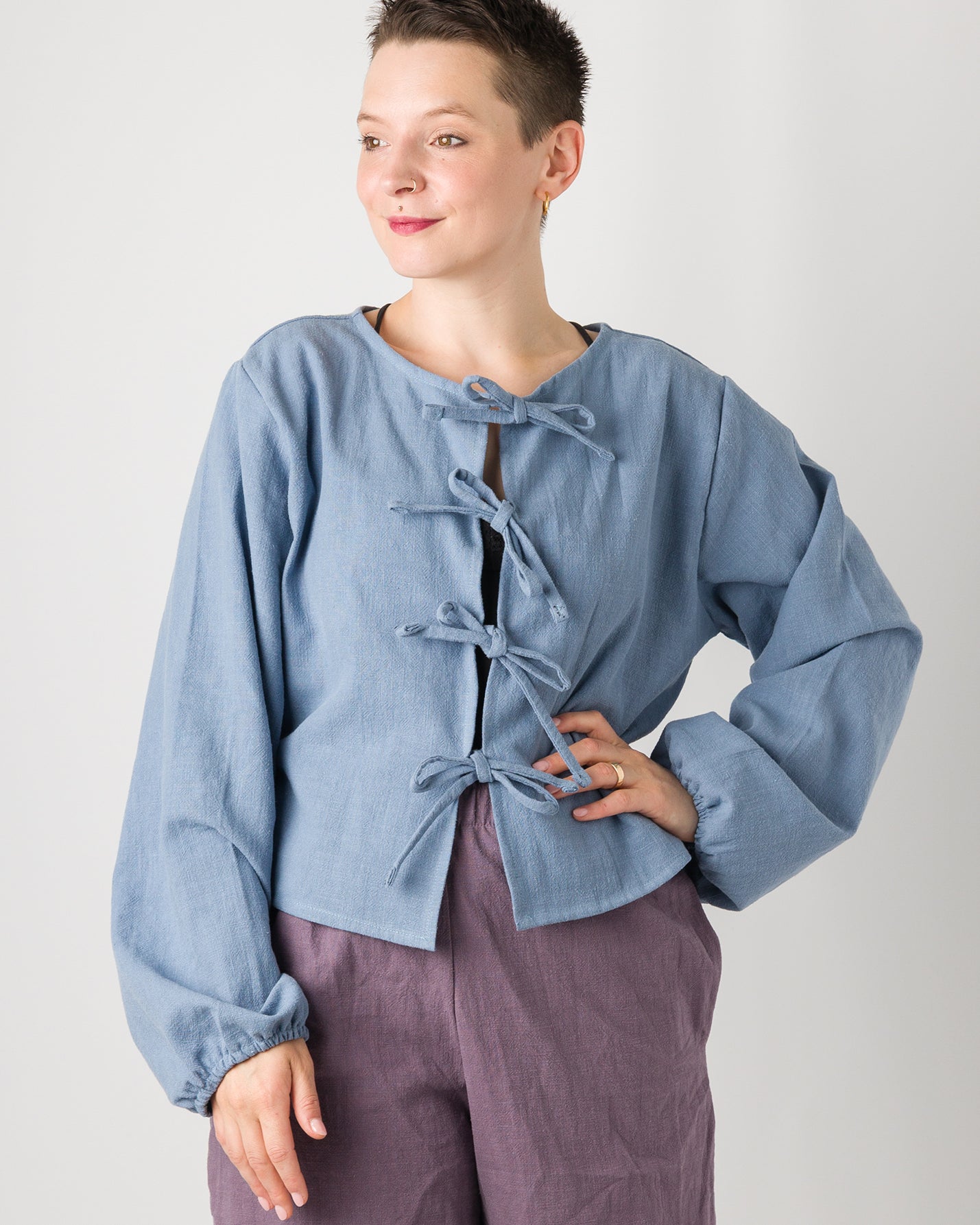 Melly trägt auf dem Foto 'Bella' mit Ballonärmeln Größe XL, Leinen stonewashed hellblau und 'Kira' Größe M, Leinen stonewashed pflaume