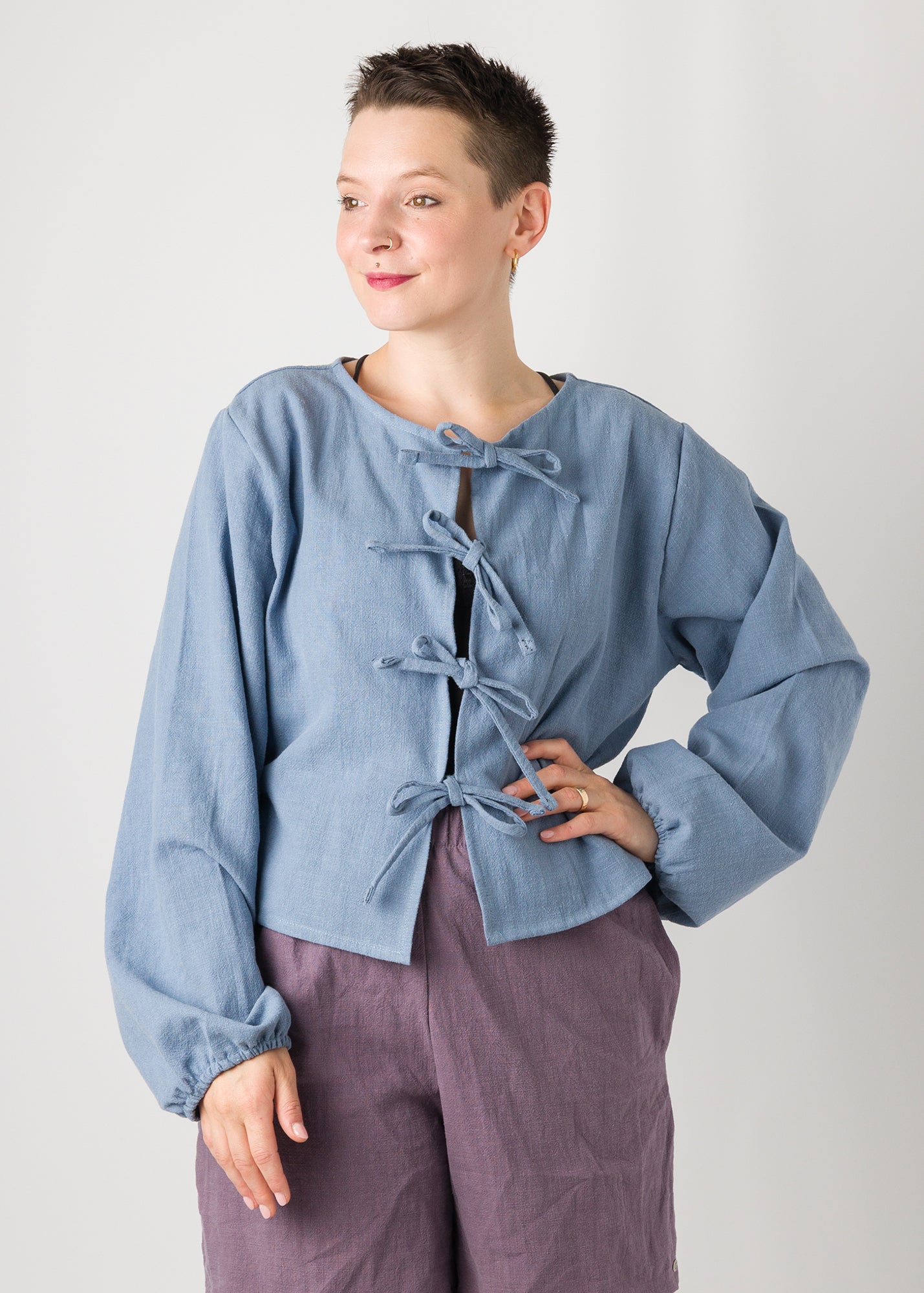 Melly trägt auf dem Foto 'Bella' mit Ballonärmeln Größe XL, Leinen stonewashed hellblau und 'Kira' Größe M, Leinen stonewashed pflaume