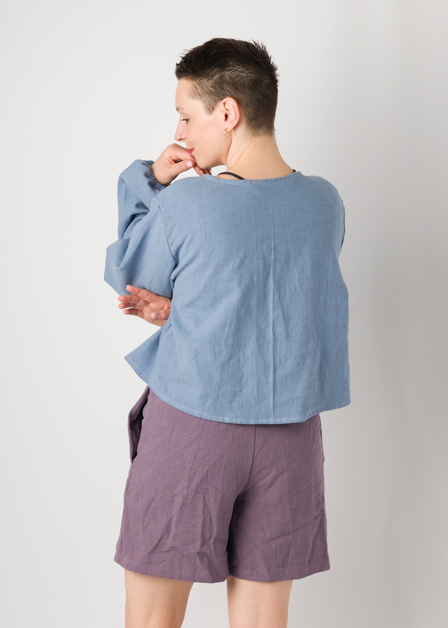 Melly trägt auf dem Foto 'Bella' mit Ballonärmeln Größe XL, Leinen stonewashed hellblau und 'Kira' Größe M, Leinen stonewashed pflaume