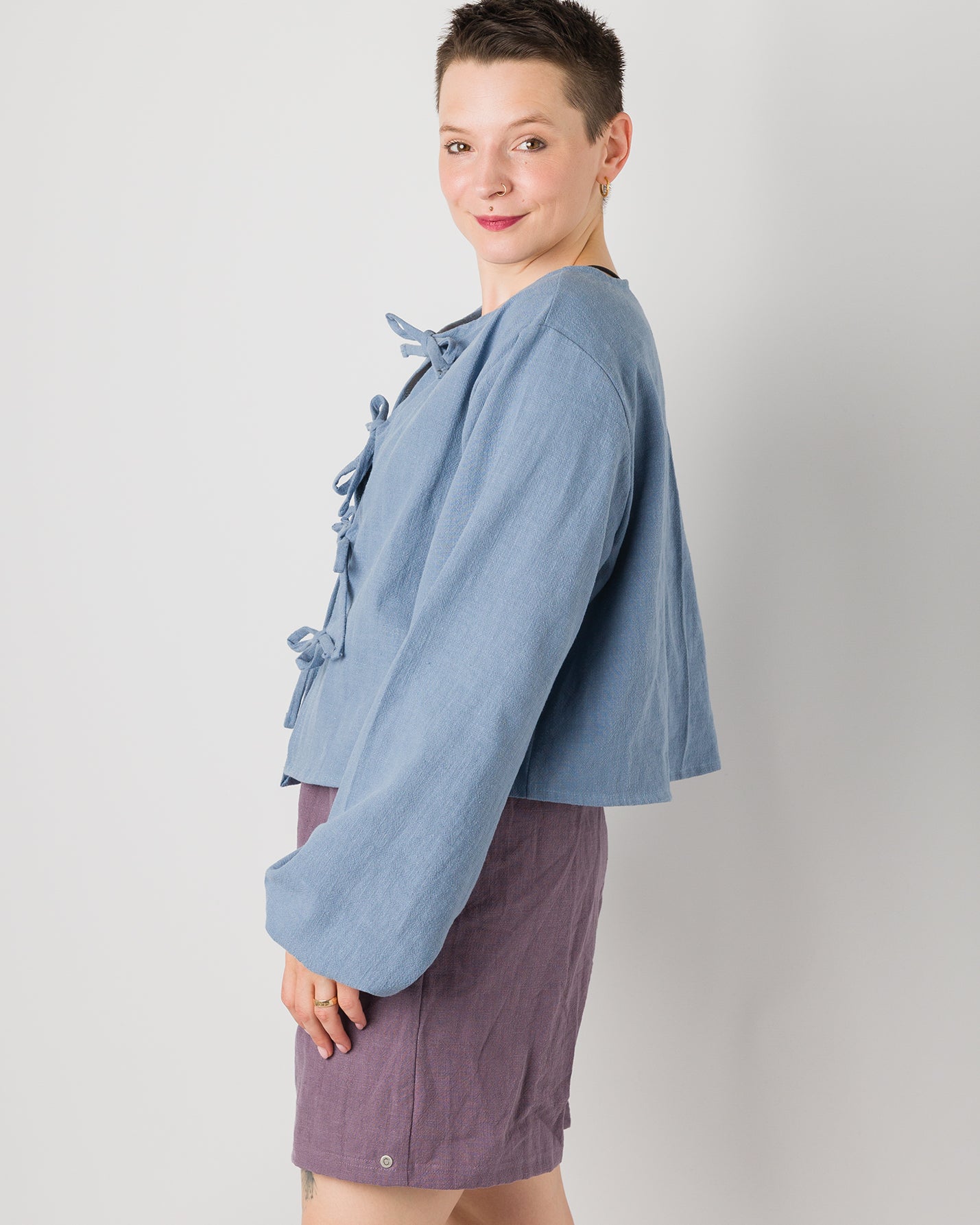 Melly trägt auf dem Foto 'Bella' mit Ballonärmeln Größe XL, Leinen stonewashed hellblau und 'Kira' Größe M, Leinen stonewashed pflaume