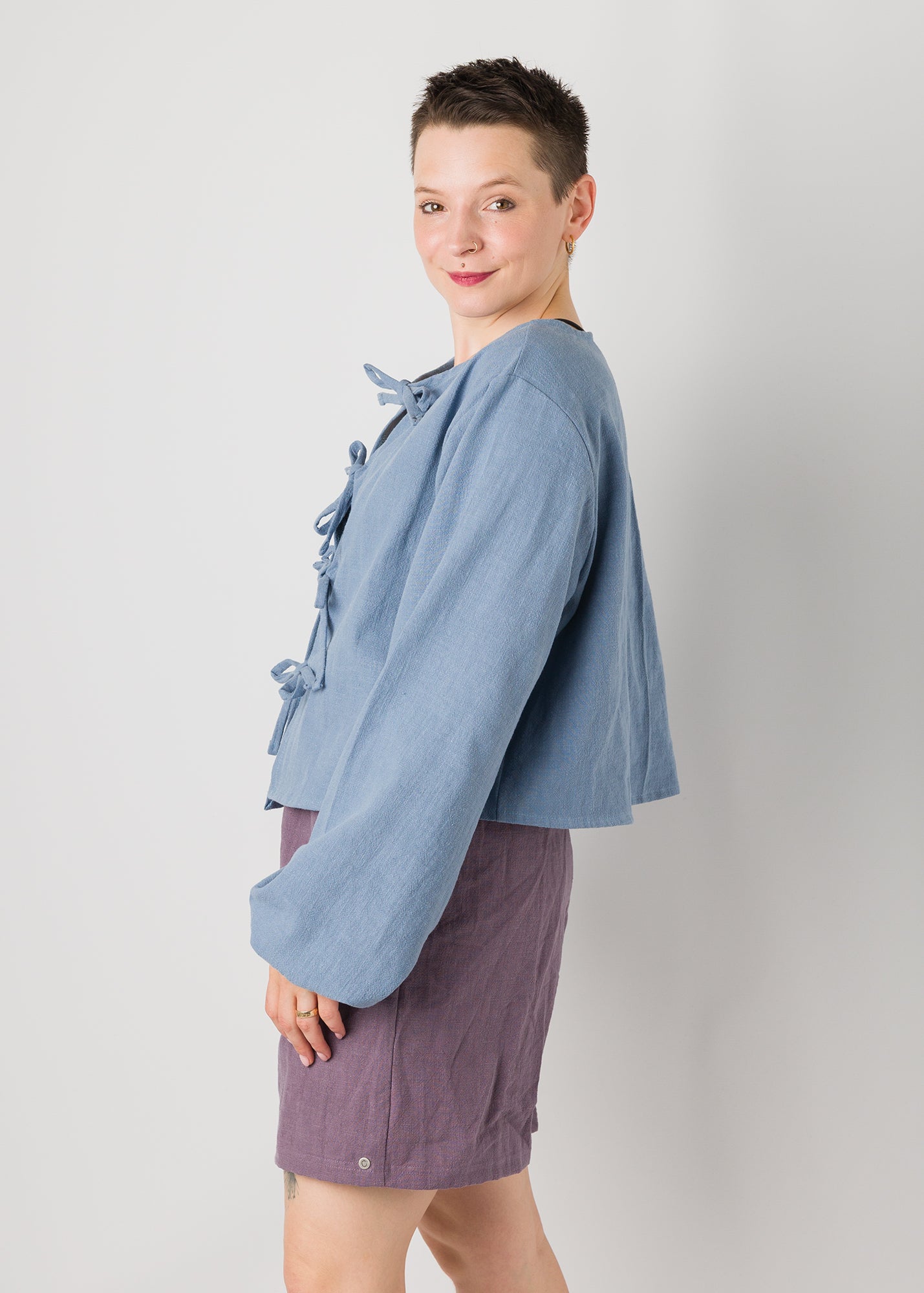 Melly trägt auf dem Foto 'Bella' mit Ballonärmeln Größe XL, Leinen stonewashed hellblau und 'Kira' Größe M, Leinen stonewashed pflaume