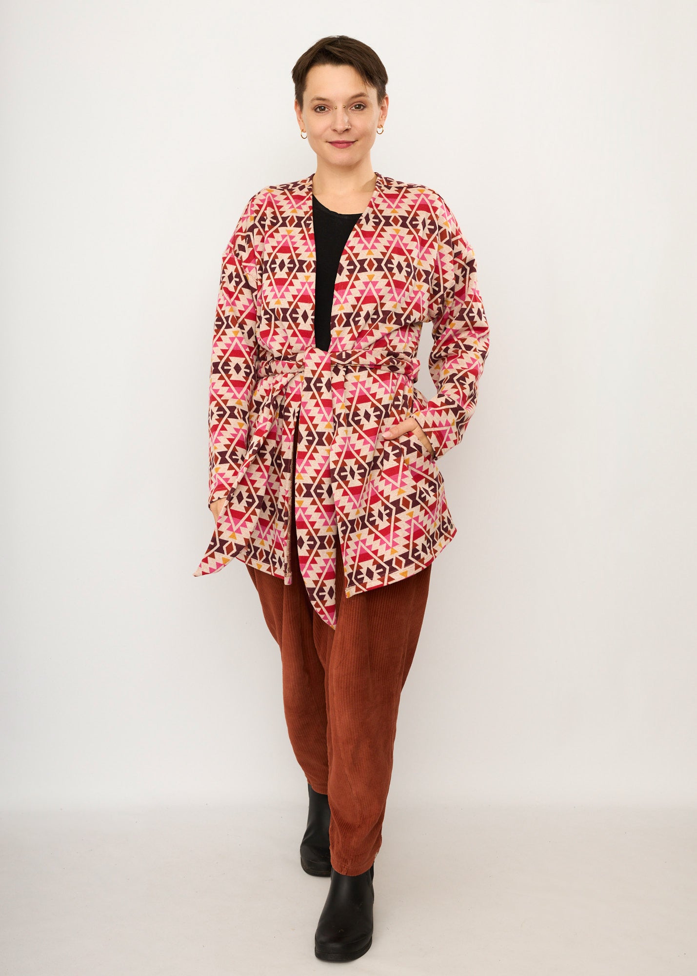 Melly trägt auf dem Foto 'Cora' Größe S, Muster elastisch, Jacquardstrick Pink-rot und 'Betty' Größe M, Velvet-Cord rostrot