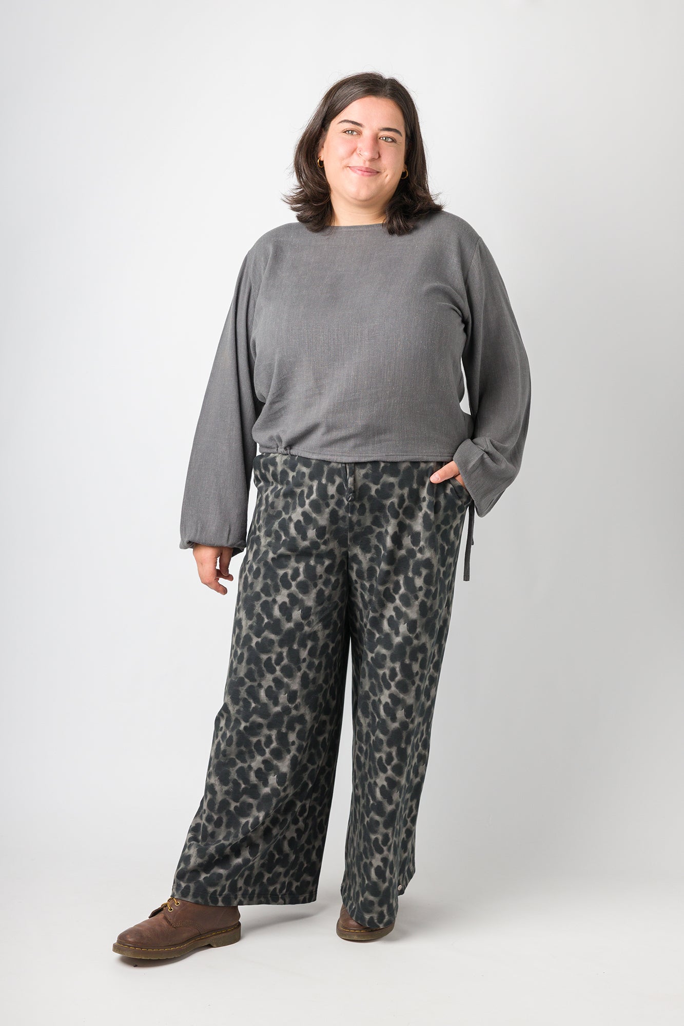 Flores trägt auf dem Foto 'Greta' mit Ballonärmel Größe XL, EcoVeroLeinen grau und 'Holly' weites Bein Größe XXL, Muster elastisch 'Dark Leobert'