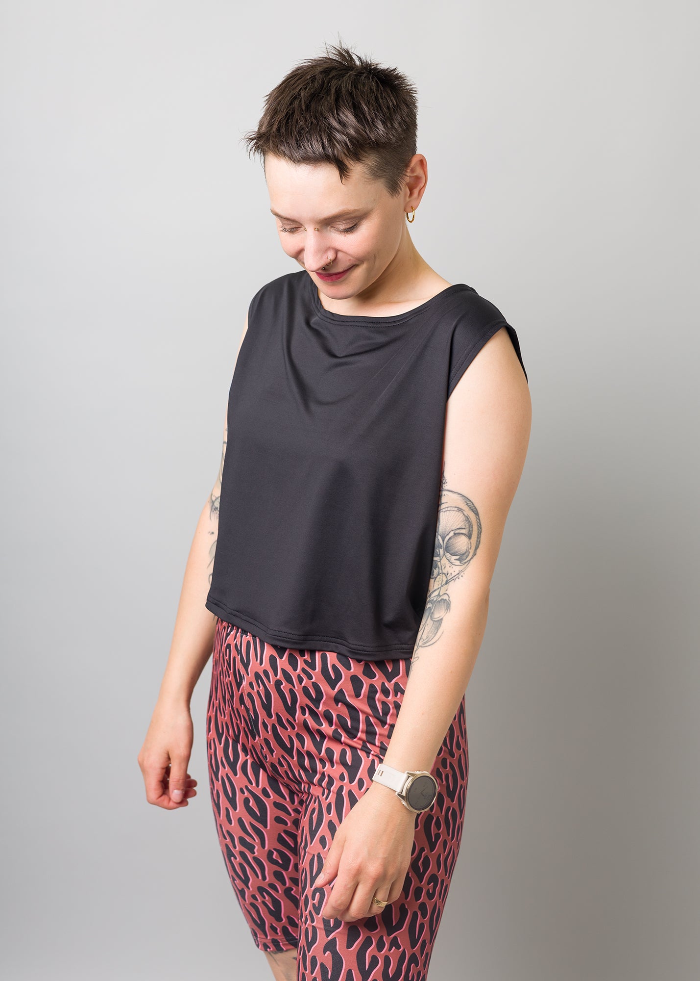 Melly trägt auf dem Foto 'Gerda' ohne Ärmel Größe S und 'Rea' Größe M, Funktionsstoff schwarz und 'Leo'