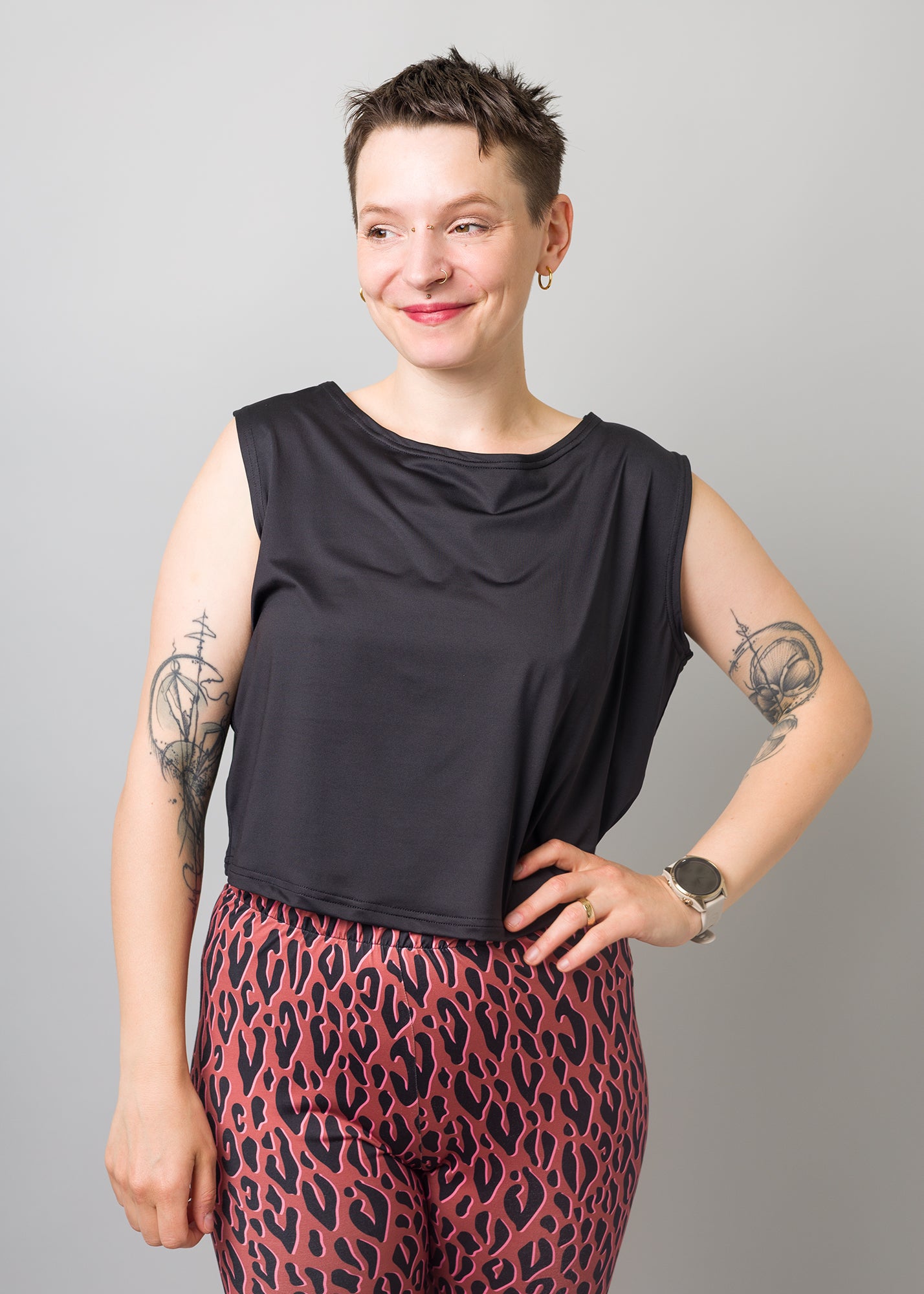 Melly trägt auf dem Foto 'Gerda' ohne Ärmel Größe S und 'Rea' Größe M, Funktionsstoff schwarz und 'Leo'