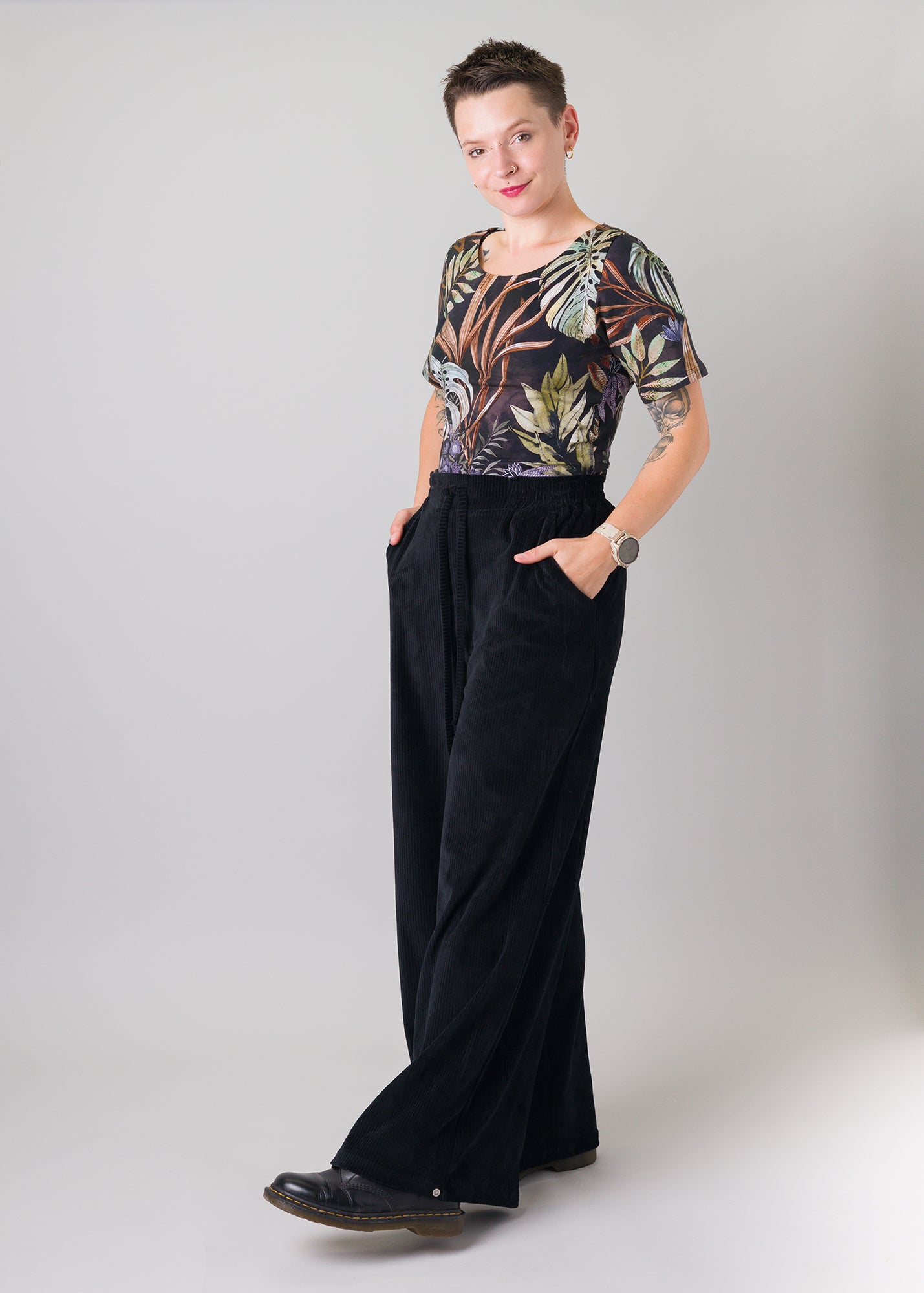 Melly trägt auf dem Foto 'Conni' kurzarm Größe S, Muster elastisch 'Plantlover' und 'Holly' weites Bein Größe XS, Velvet-Cord schwarz