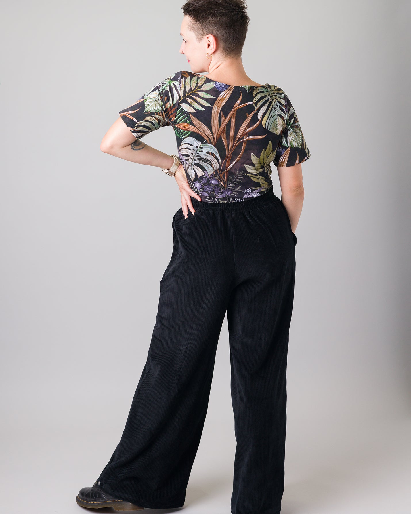 Melly trägt auf dem Foto 'Conni' kurzarm Größe S, Muster elastisch 'Plantlover' und 'Holly' weites Bein Größe XS, Velvet-Cord schwarz