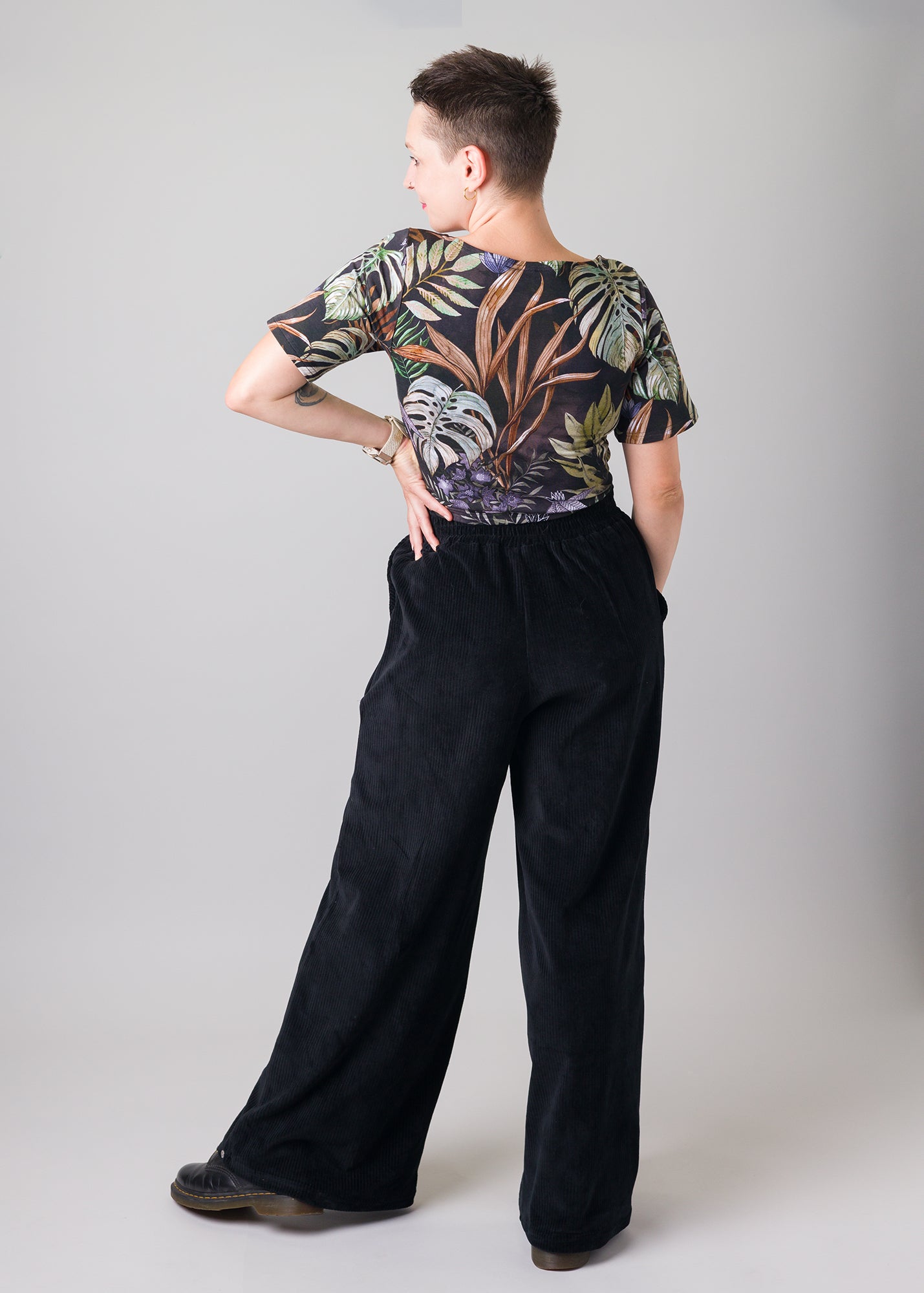 Melly trägt auf dem Foto 'Conni' kurzarm Größe S, Muster elastisch 'Plantlover' und 'Holly' weites Bein Größe XS, Velvet-Cord schwarz