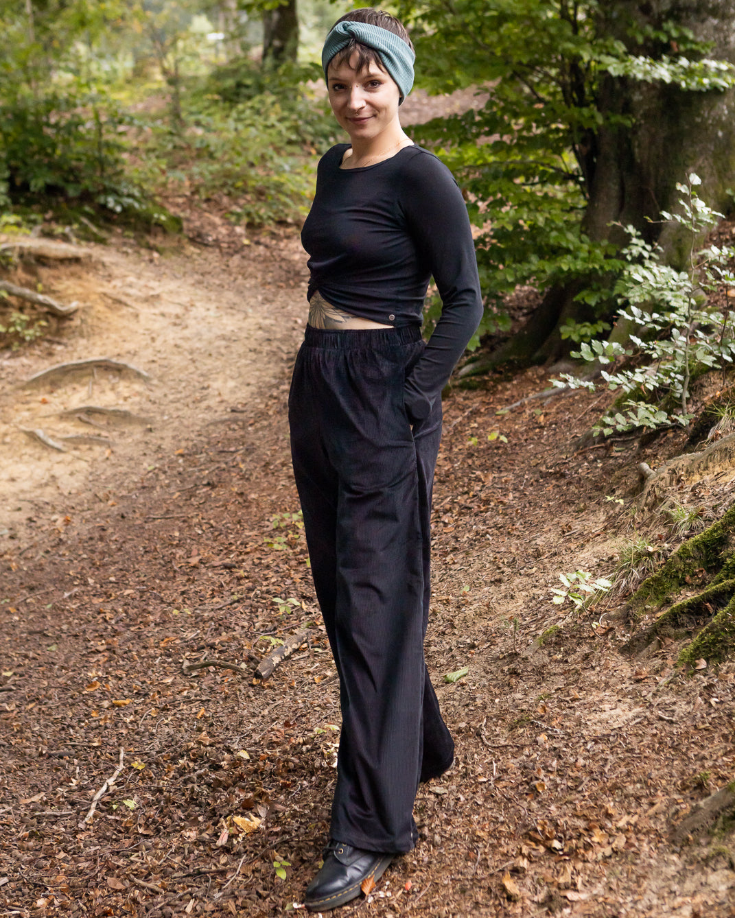 Melly trägt auf dem Foto 'Marlene' Größe M, Cord schwarz und 'Clara' Größe M, Rippjersey schwarz