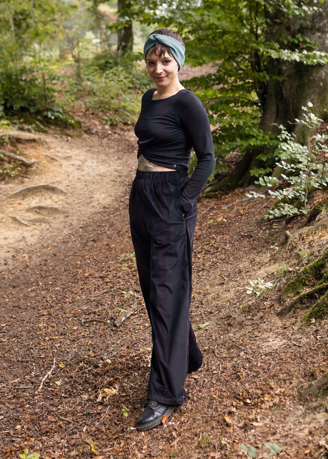 Melly trägt auf dem Foto 'Marlene' Größe M, Cord schwarz und 'Clara' Größe M, Rippjersey schwarz