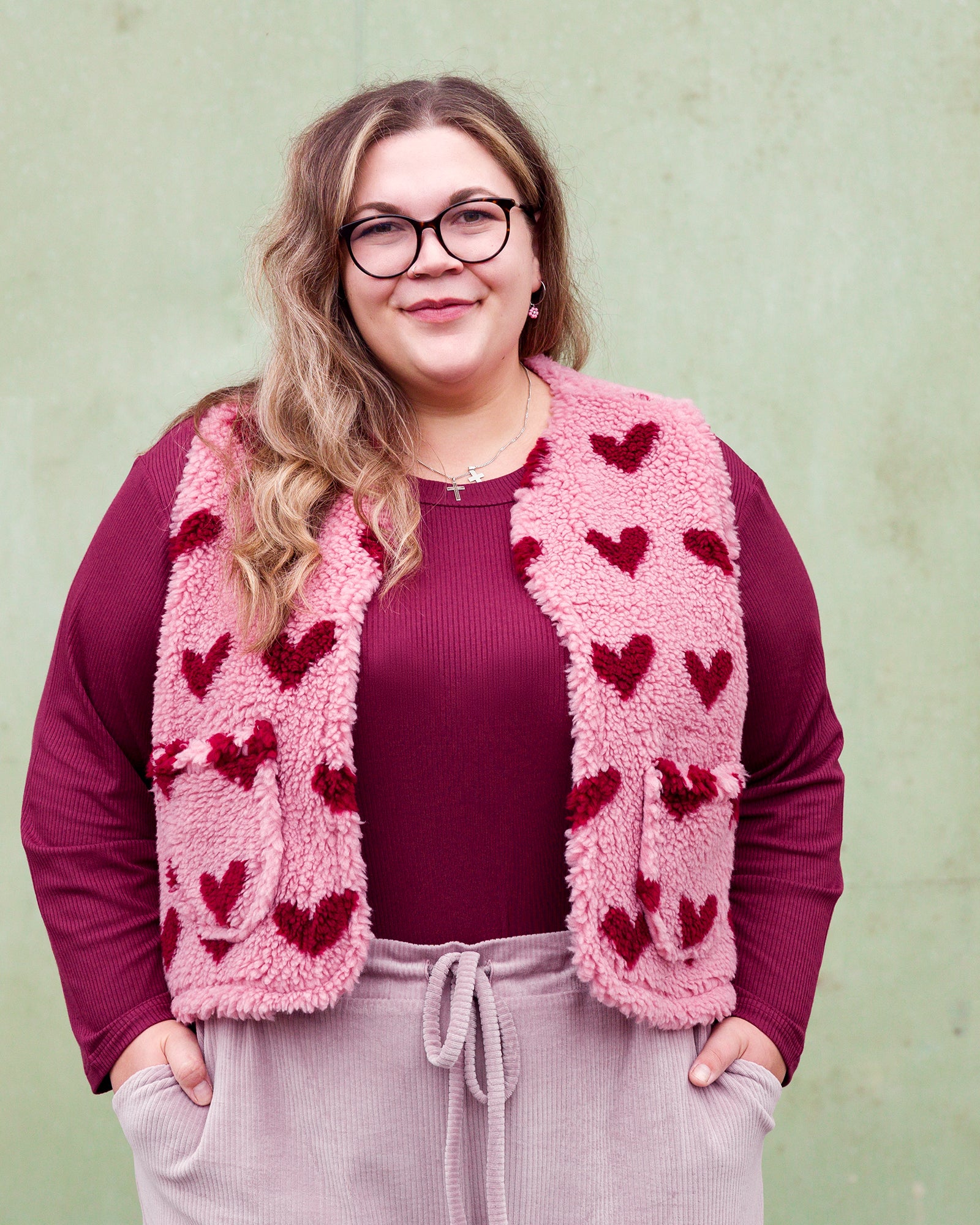 Vroni trägt auf dem Foto 'Theo' Größe 4XL, Rippjersey burgund und 'Waltraut' mit Taschen Größe 4XL/5XL, Muster Plüsch 'Herzchen rosa-rot'