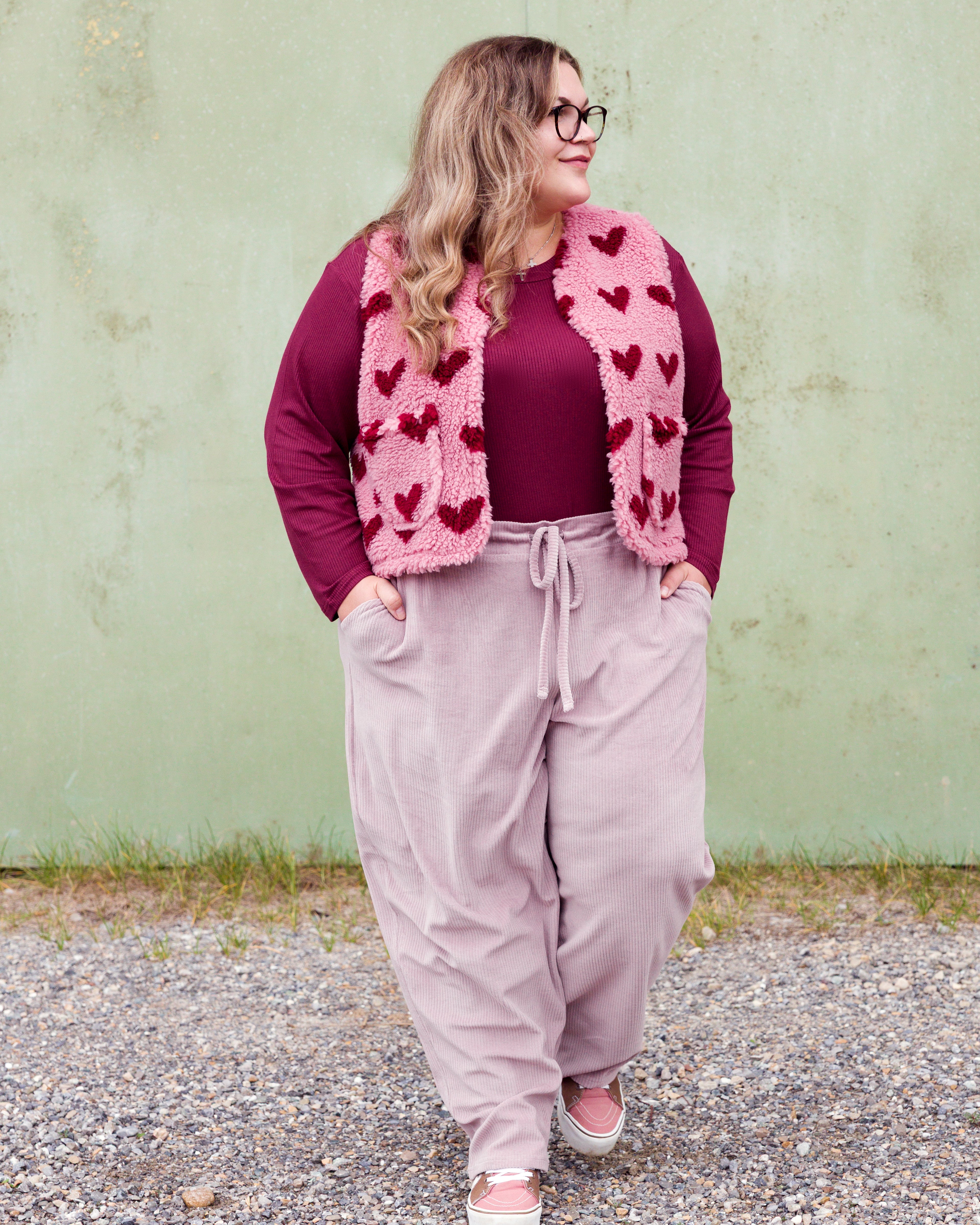 Vroni trägt auf dem Foto 'Theo' Größe 4XL, Rippjersey burgund, 'Waltraut' mit Taschen Größe 4XL/5XL, Muster Plüsch 'Herzchen rosa-rot' und 'Holly' schmales Bein Größe 4XL, Velvet-Cord flieder