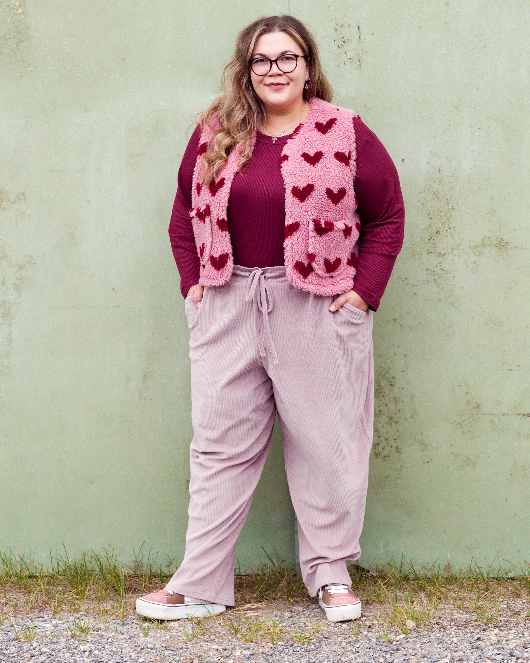 Vroni trägt auf dem Foto 'Theo' Größe 4XL, Rippjersey burgund, 'Waltraut' mit Taschen Größe 4XL/5XL, Muster Plüsch 'Herzchen rosa-rot' und 'Holly' schmales Bein Größe 4XL, Velvet-Cord flieder