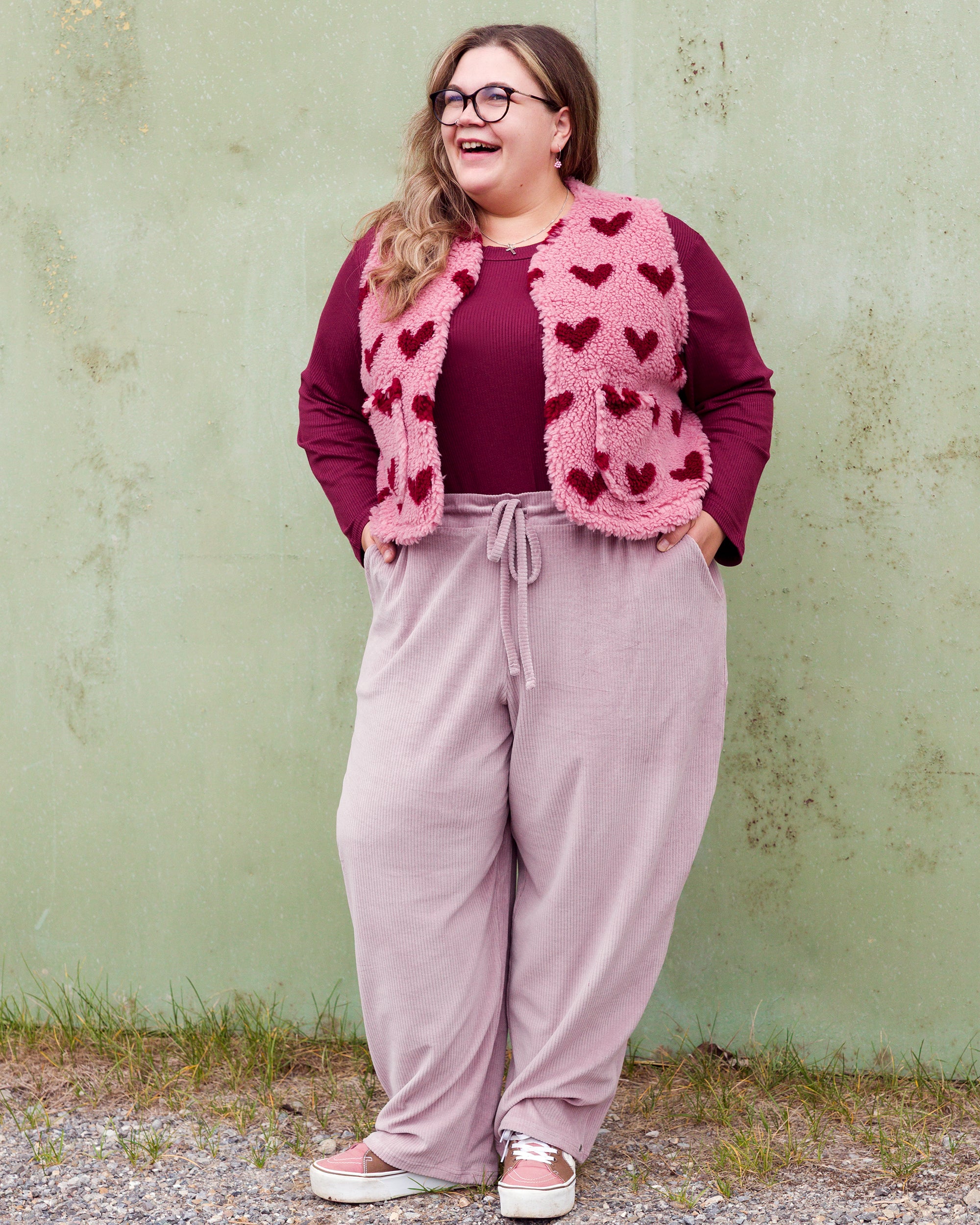 Vroni trägt auf dem Foto 'Theo' Größe 4XL, Rippjersey burgund, 'Waltraut' mit Taschen Größe 4XL/5XL, Muster Plüsch 'Herzchen rosa-rot' und 'Holly' schmales Bein Größe 4XL, Velvet-Cord flieder