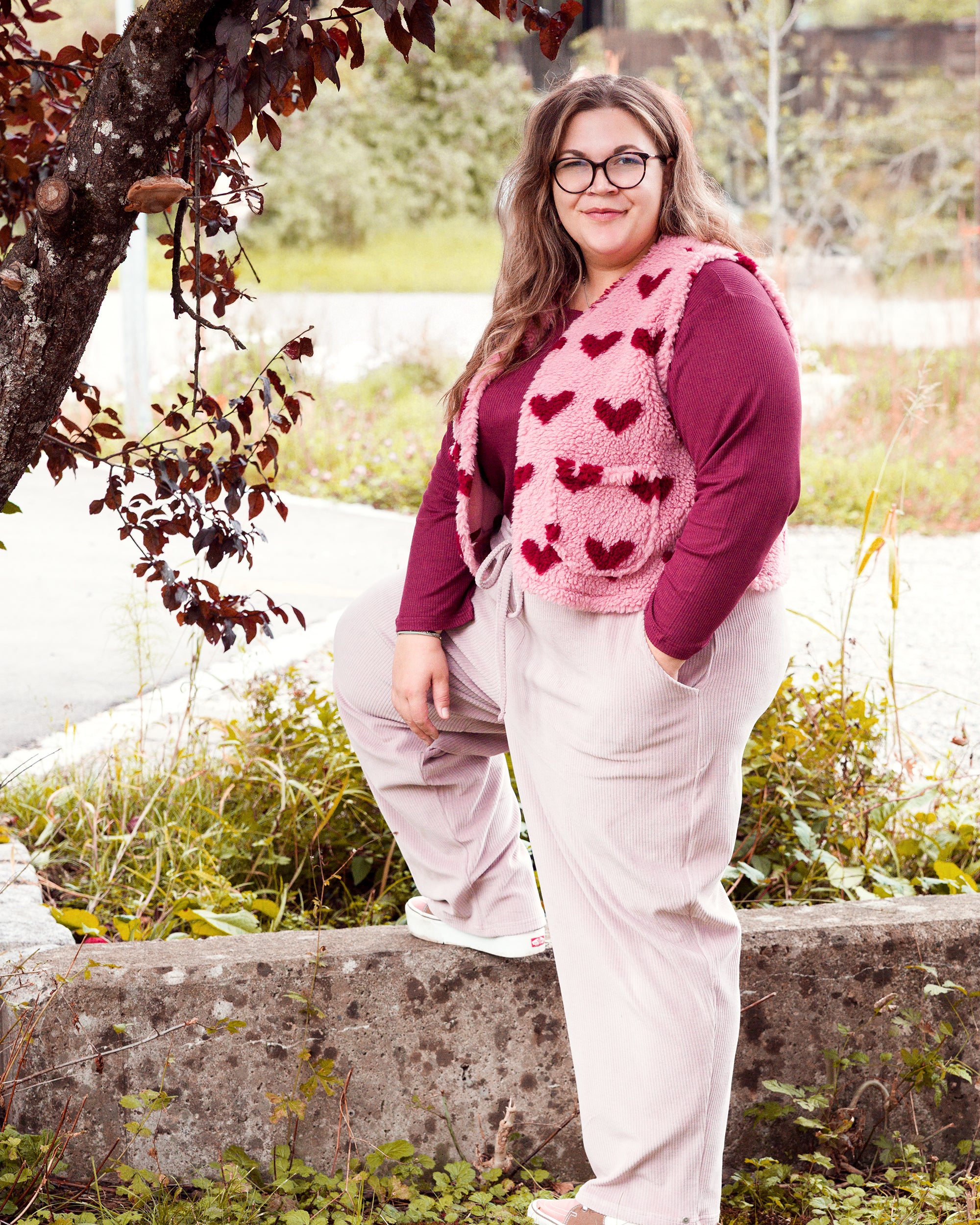 Vroni trägt auf dem Foto 'Theo' Größe 4XL, Rippjersey burgund, 'Waltraut' mit Taschen Größe 4XL/5XL, Muster Plüsch 'Herzchen rosa-rot' und 'Holly' schmales Bein Größe 4XL, Velvet-Cord flieder