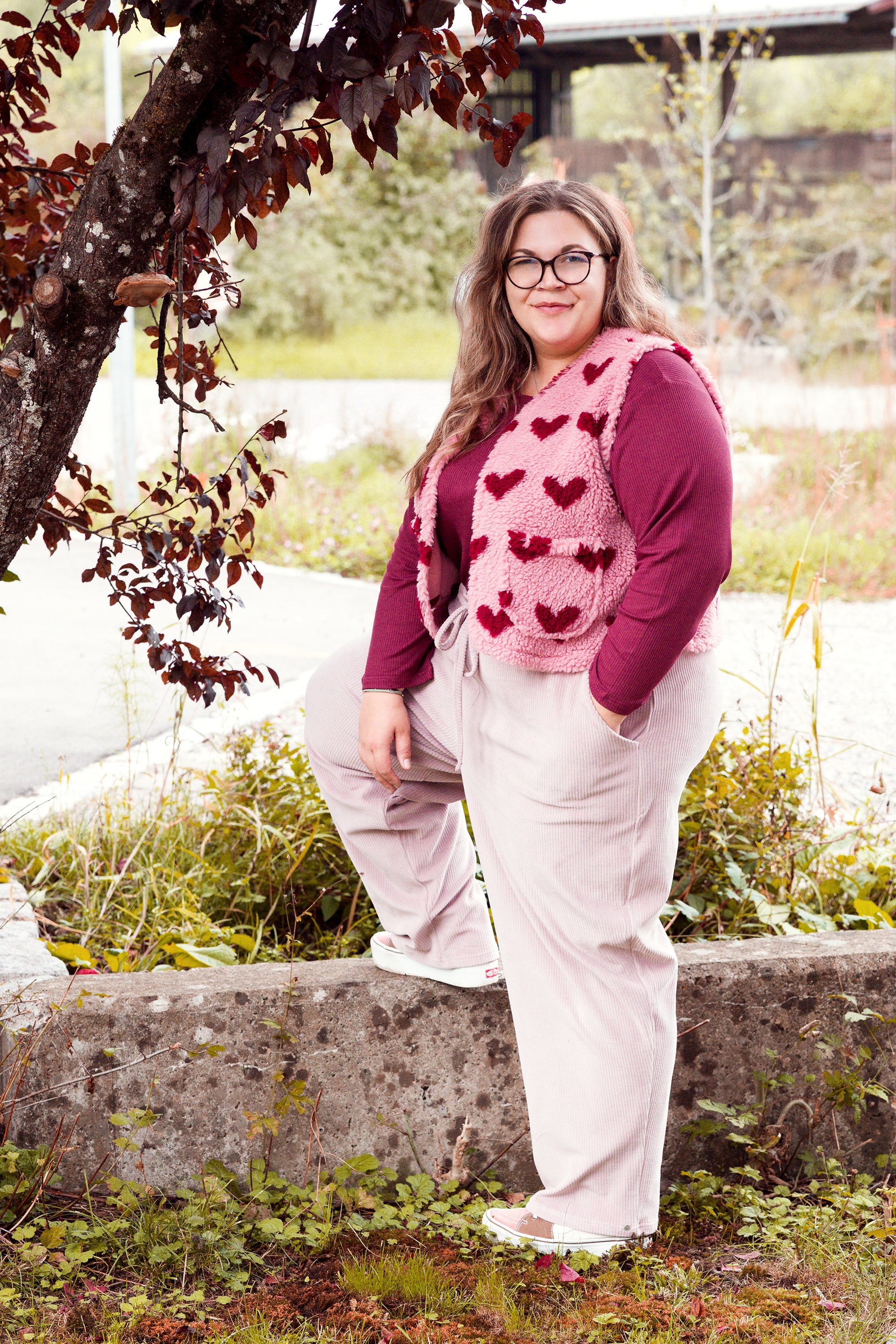 Vroni trägt auf dem Foto 'Theo' Größe 4XL, Rippjersey burgund, 'Waltraut' mit Taschen Größe 4XL/5XL, Muster Plüsch 'Herzchen rosa-rot' und 'Holly' schmales Bein Größe 4XL, Velvet-Cord flieder