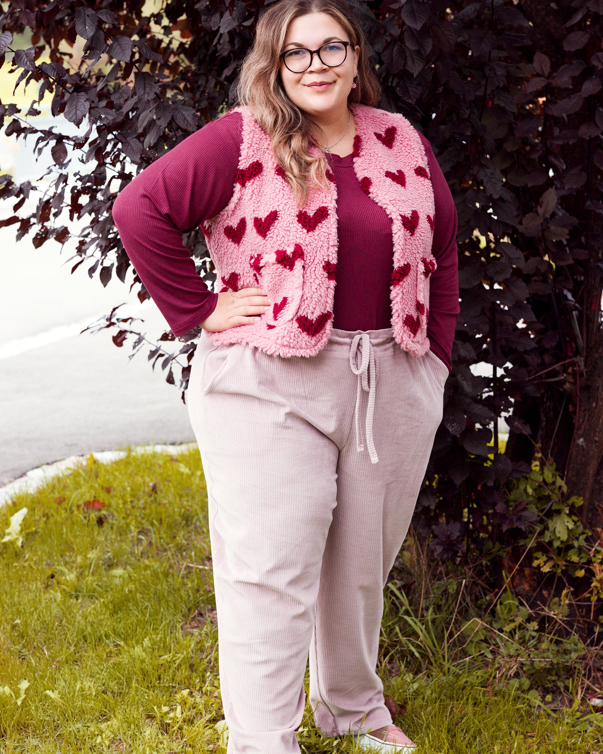 Vroni trägt auf dem Foto 'Theo' Größe 4XL, Rippjersey burgund, 'Waltraut' mit Taschen Größe 4XL/5XL, Muster Plüsch 'Herzchen rosa-rot' und 'Holly' schmales Bein Größe 4XL, Velvet-Cord flieder