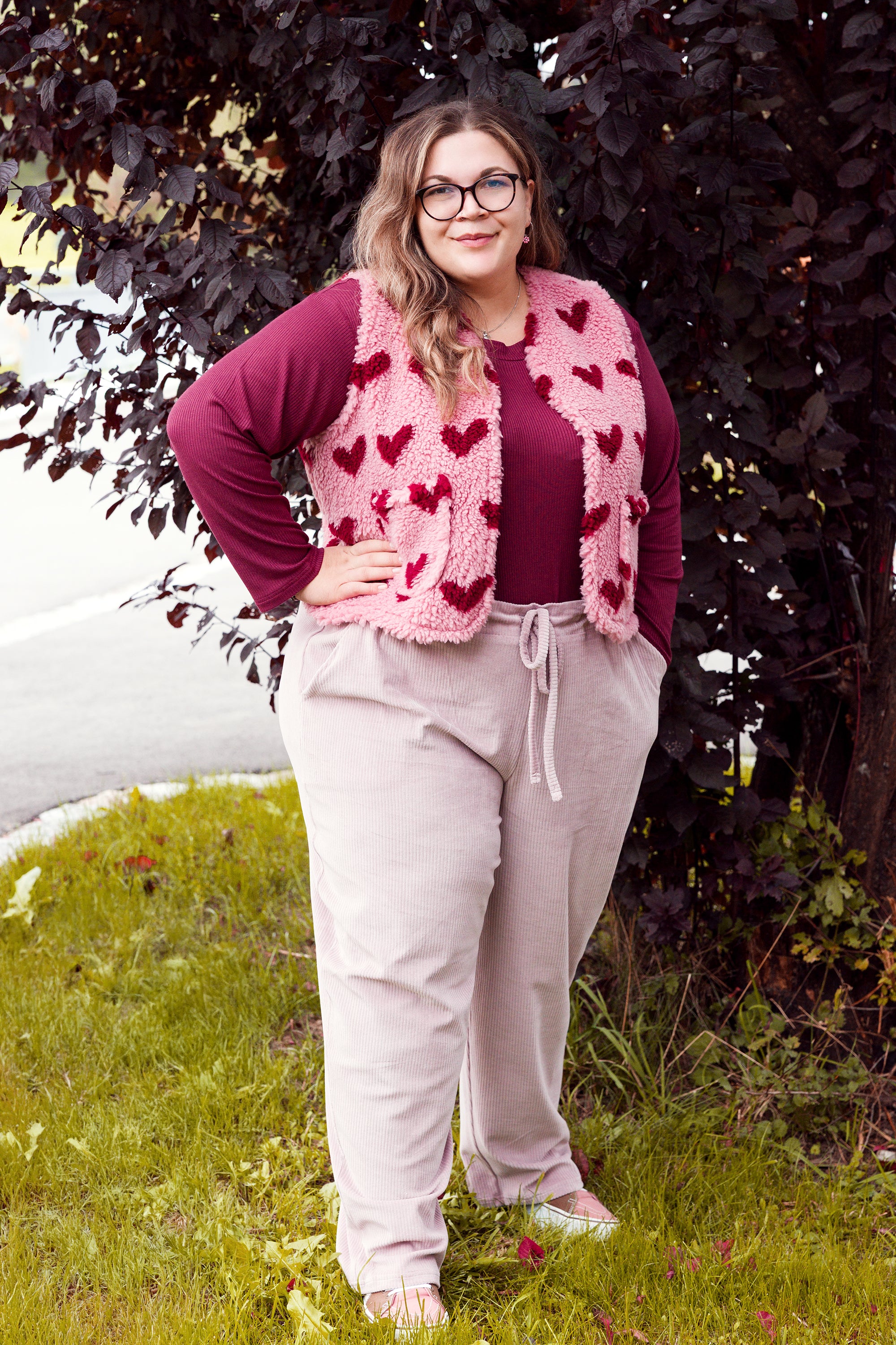 Vroni trägt auf dem Foto 'Theo' Größe 4XL, Rippjersey burgund, 'Waltraut' mit Taschen Größe 4XL/5XL, Muster Plüsch 'Herzchen rosa-rot' und 'Holly' schmales Bein Größe 4XL, Velvet-Cord flieder