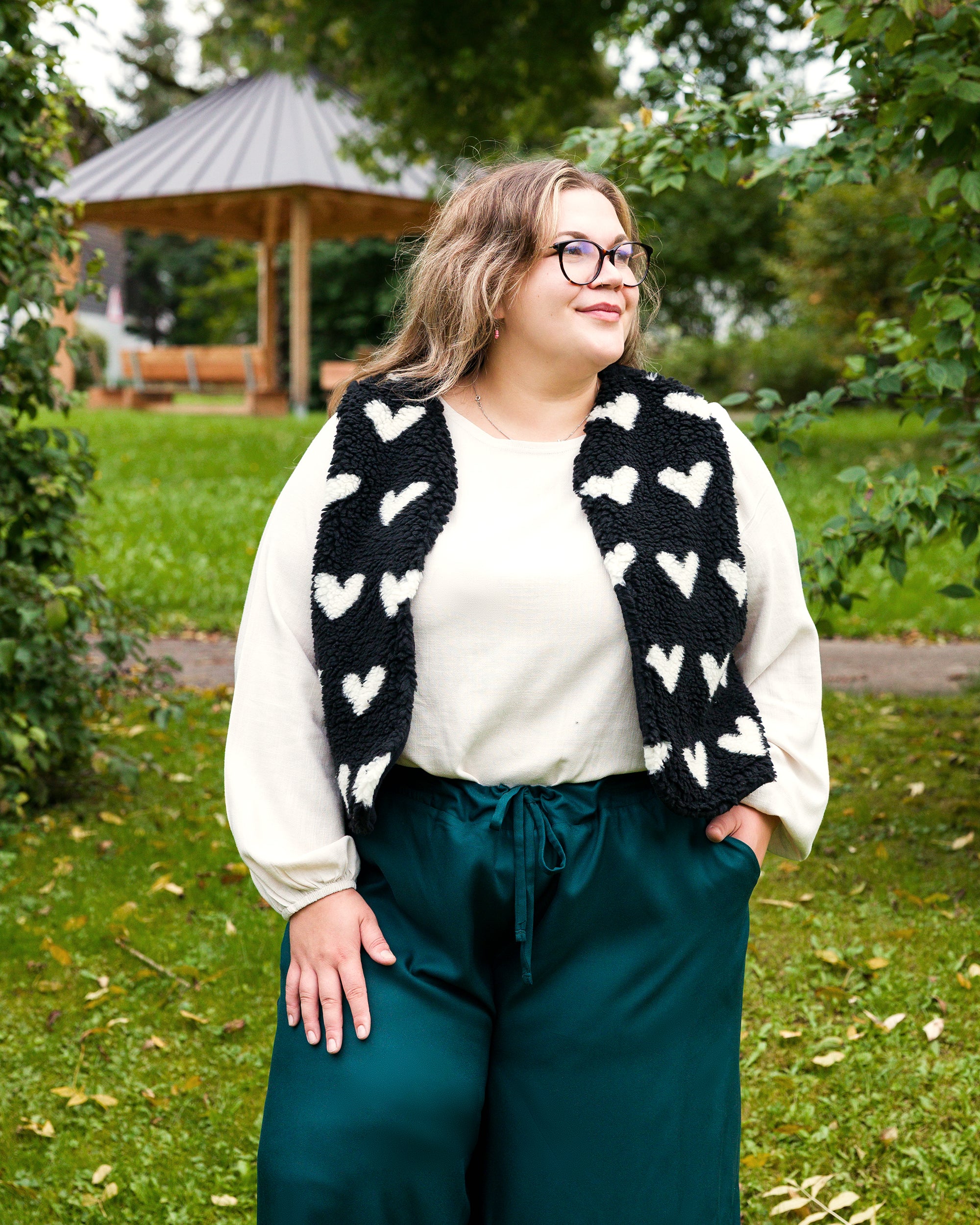 Vroni trägt auf dem Foto 'Greta' Größe 4XL, EcoVero Leinen creme, 'Waltraut' Größe 4XL/5XL, Plüsch Herzchen schwarz-creme und 'Holly' weites Bein Größe 5XL, EcoVeroCrepe flaschengrün