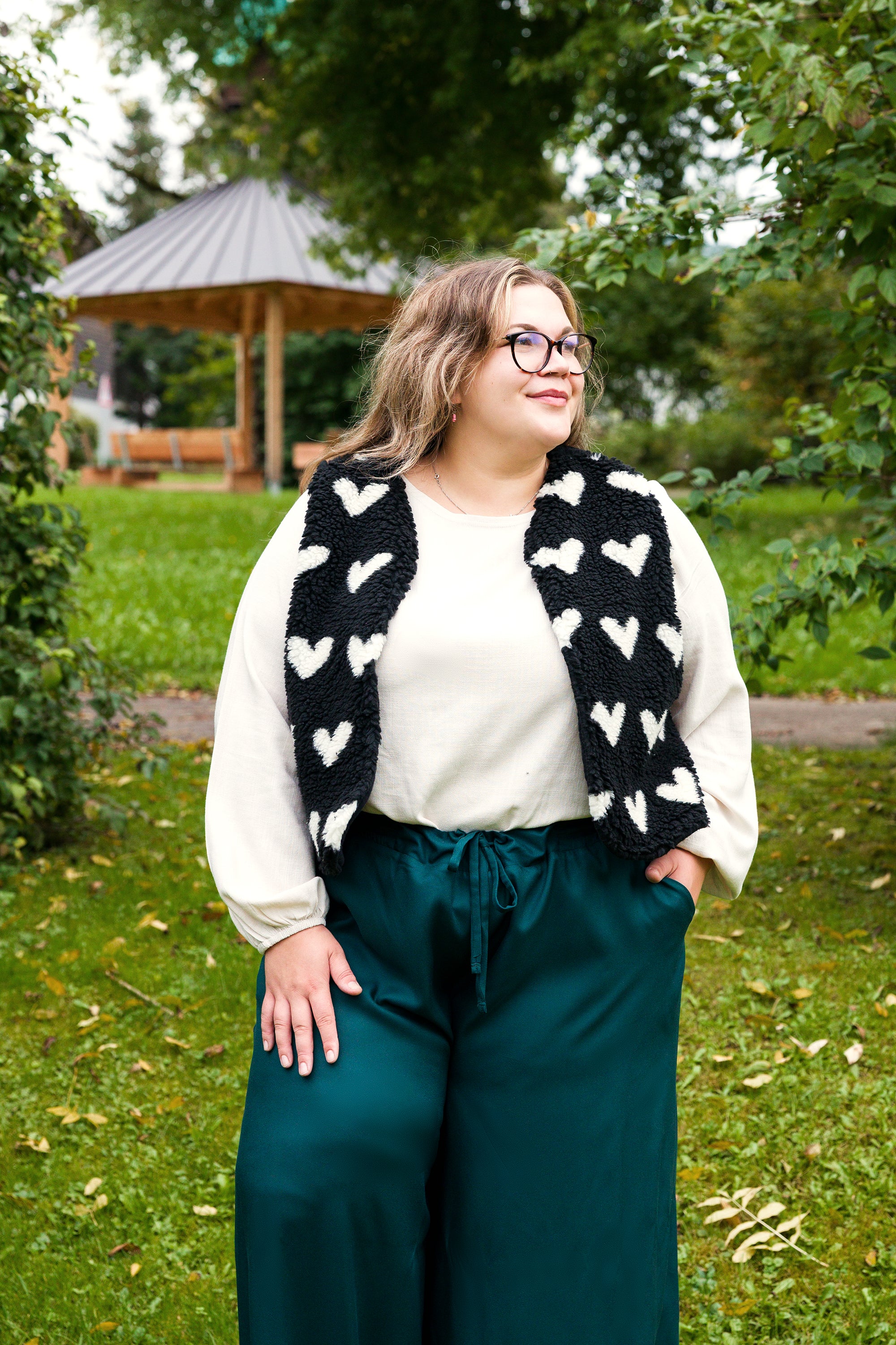 Vroni trägt auf dem Foto 'Greta' Größe 4XL, EcoVero Leinen creme, 'Waltraut' Größe 4XL/5XL, Plüsch Herzchen schwarz-creme und 'Holly' weites Bein Größe 5XL, EcoVeroCrepe flaschengrün