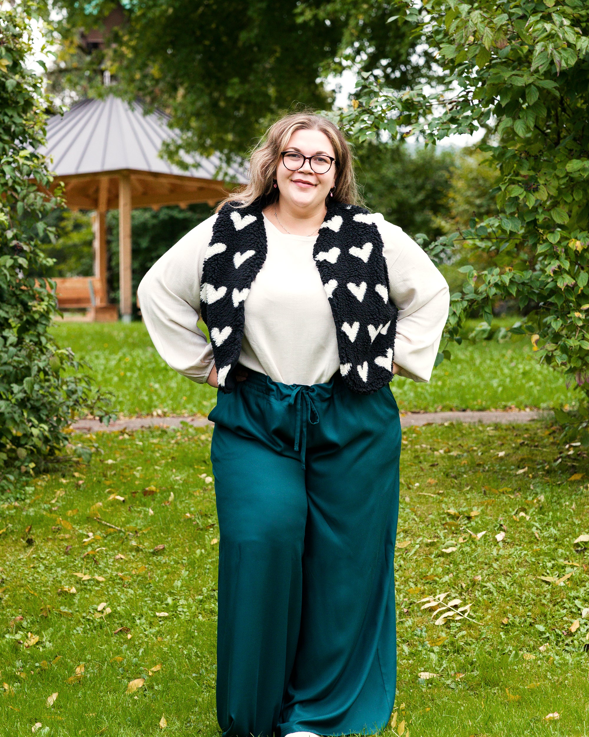 Vroni trägt auf dem Foto 'Greta' Größe 4XL, EcoVero Leinen creme, 'Waltraut' Größe 4XL/5XL, Plüsch Herzchen schwarz-creme und 'Holly' weites Bein Größe 5XL, EcoVeroCrepe flaschengrün