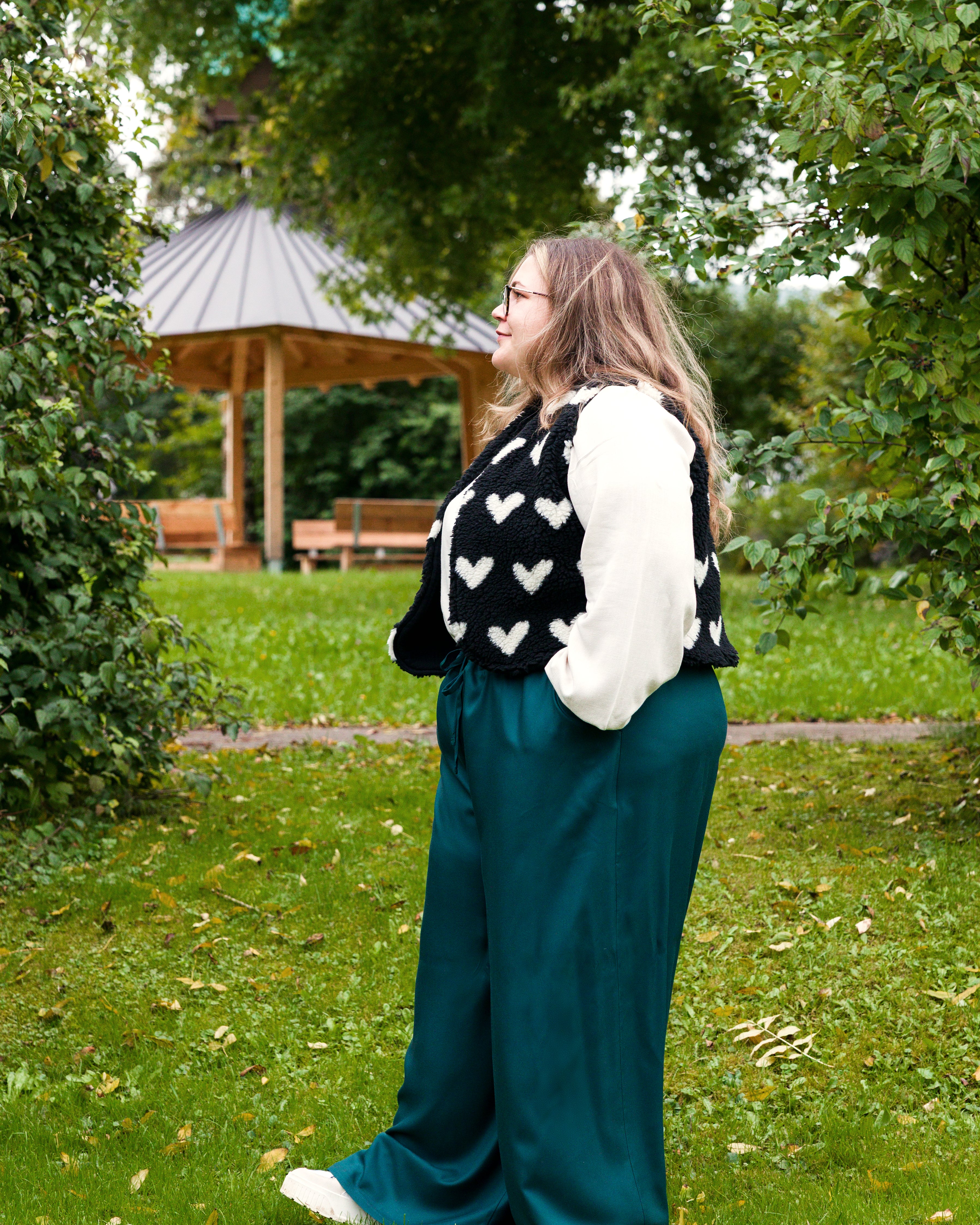 Vroni trägt auf dem Foto 'Greta' Größe 4XL, EcoVero Leinen creme, 'Waltraut' Größe 4XL/5XL, Plüsch Herzchen schwarz-creme und 'Holly' weites Bein Größe 5XL, EcoVeroCrepe flaschengrün