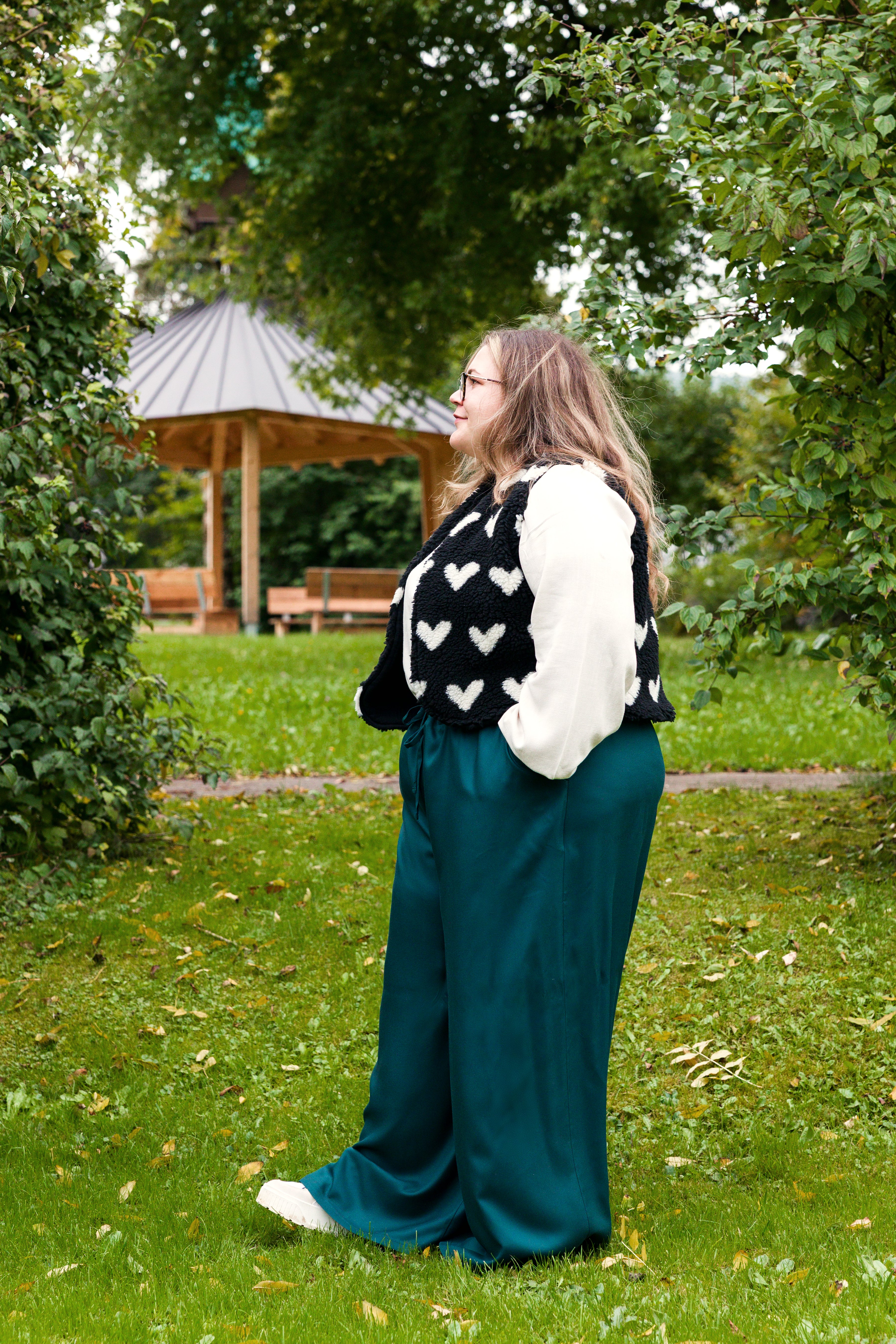 Vroni trägt auf dem Foto 'Greta' Größe 4XL, EcoVero Leinen creme, 'Waltraut' Größe 4XL/5XL, Plüsch Herzchen schwarz-creme und 'Holly' weites Bein Größe 5XL, EcoVeroCrepe flaschengrün