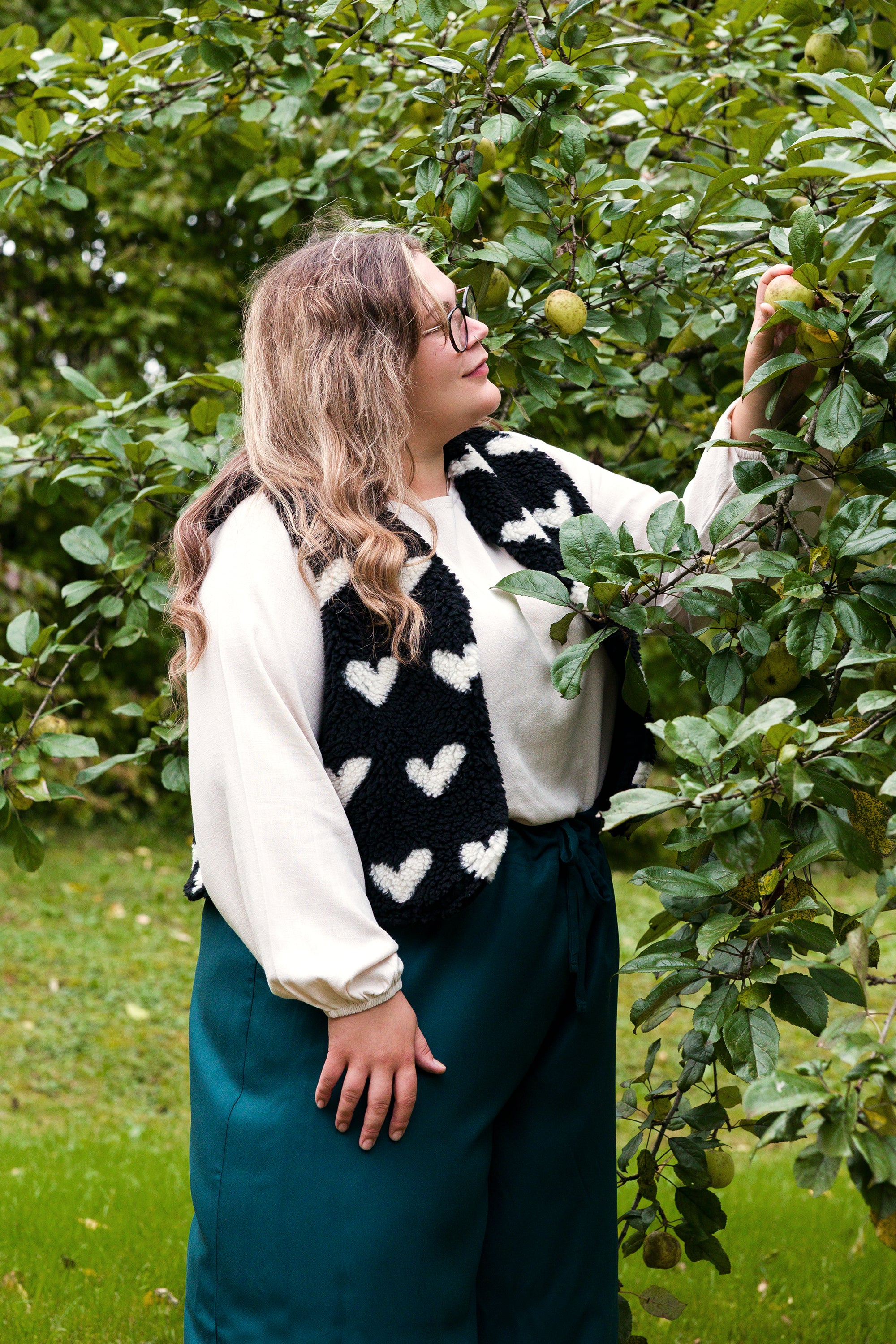 Vroni trägt auf dem Foto 'Greta' Größe 4XL, EcoVero Leinen creme, 'Waltraut' Größe 4XL/5XL, Plüsch Herzchen schwarz-creme und 'Holly' weites Bein Größe 5XL, EcoVeroCrepe flaschengrün