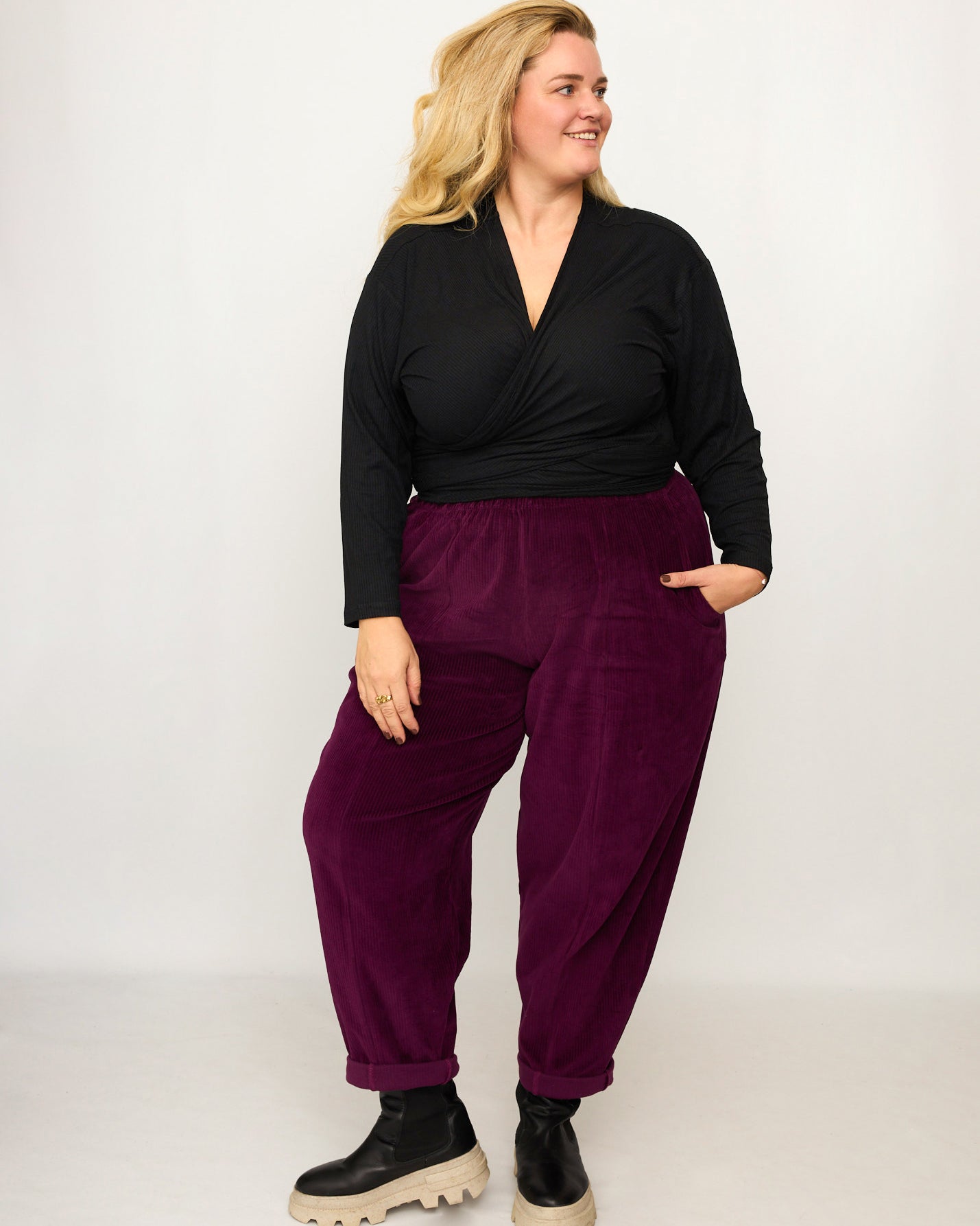 Nina trägt auf dem Foto 'Winja' Größe 3, Rippjersey schwarz und 'Betty' Größe XXXL, Velvet-Cord aubergine