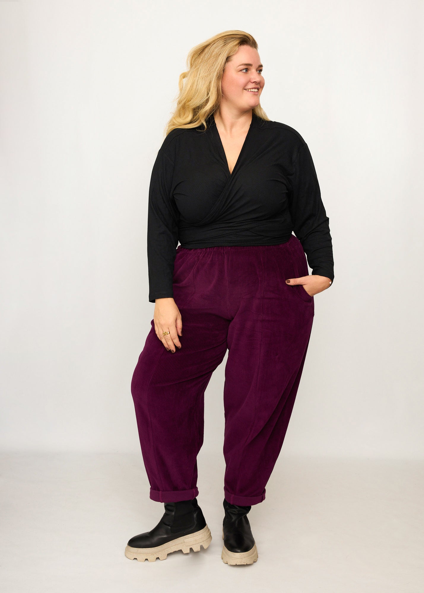 Nina trägt auf dem Foto 'Winja' Größe 3, Rippjersey schwarz und 'Betty' Größe XXXL, Velvet-Cord aubergine