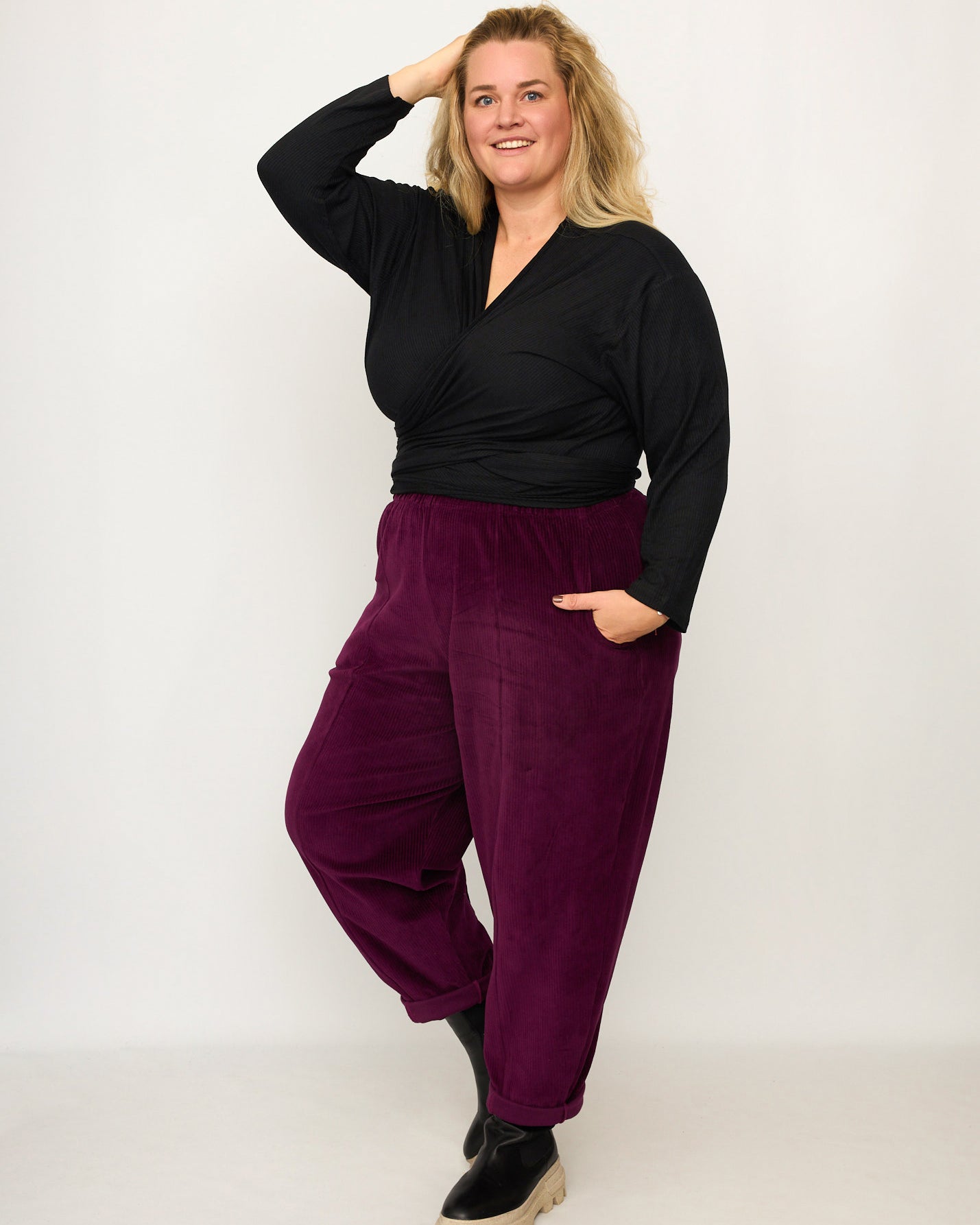 Nina trägt auf dem Foto 'Winja' Größe 3, Rippjersey schwarz und 'Betty' Größe XXXL, Velvet-Cord aubergine
