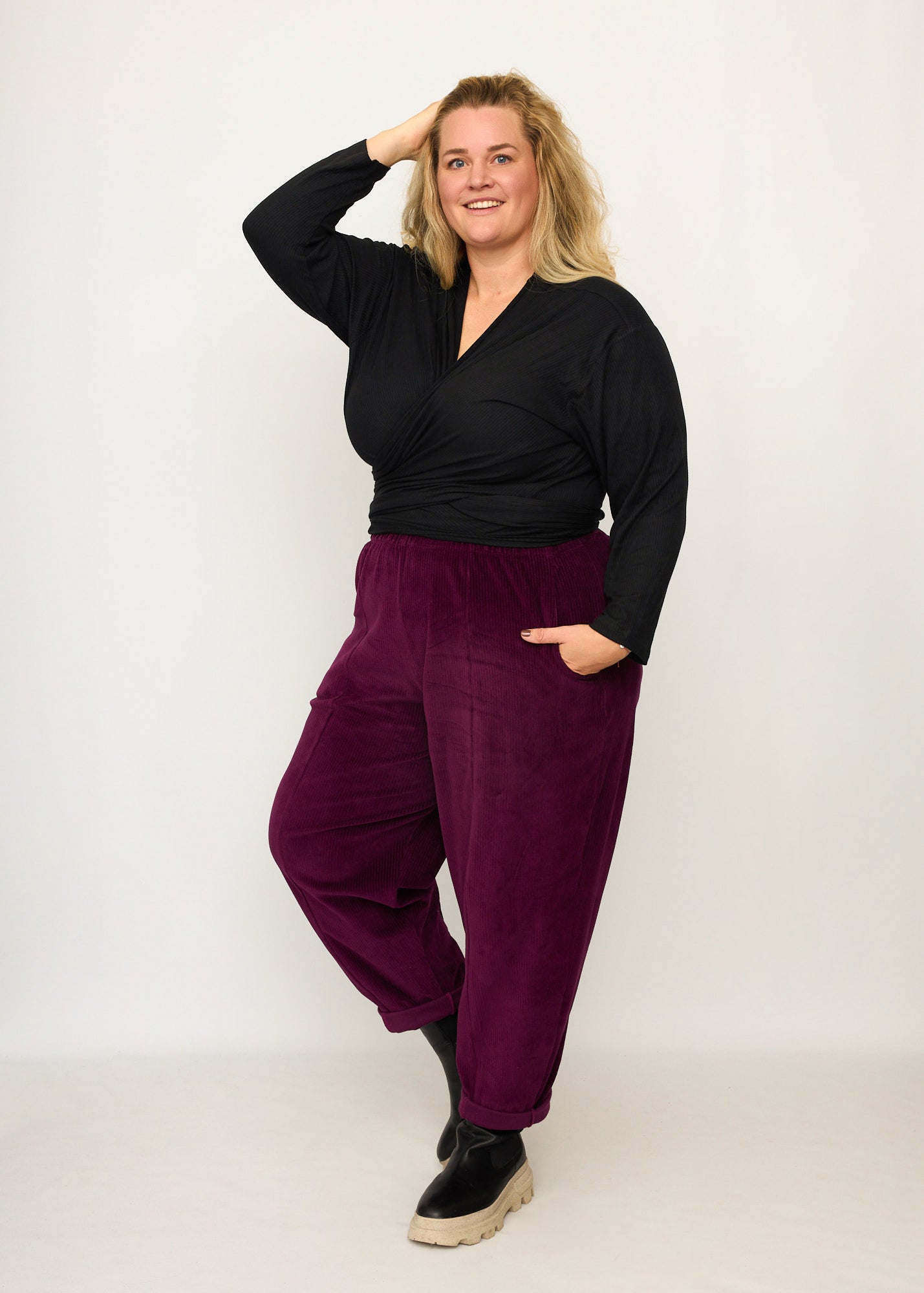Nina trägt auf dem Foto 'Winja' Größe 3, Rippjersey schwarz und 'Betty' Größe XXXL, Velvet-Cord aubergine