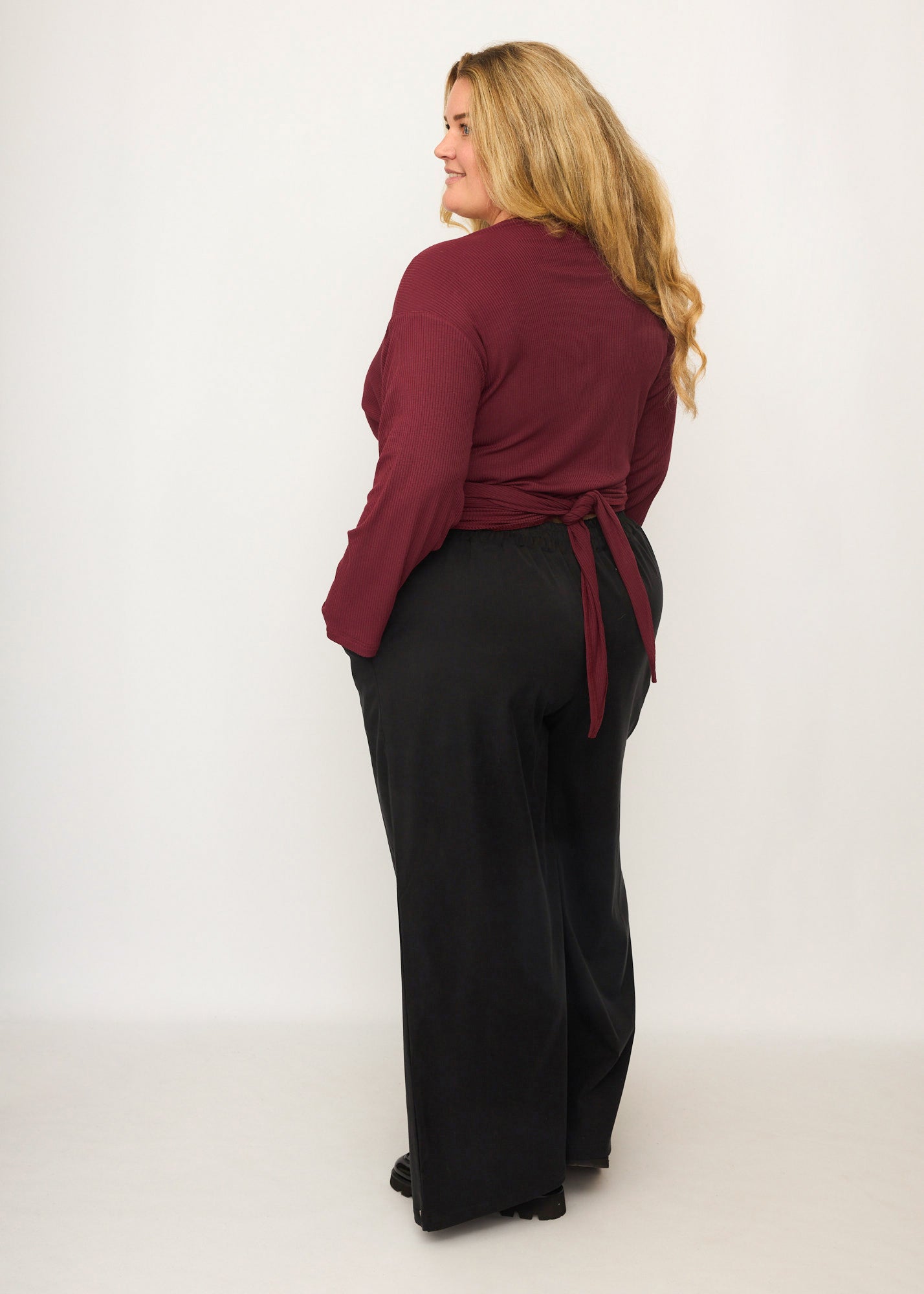 Nina trägt auf dem Foto 'Holly' weites Bein Größe 4XL, Tenceltwill schwarz und 'Winja' Größe 3, Rippjersey burgund