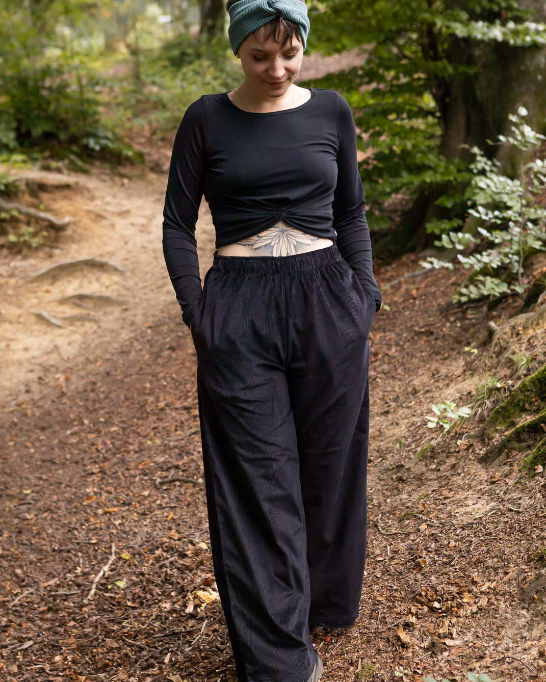 Melly trägt auf dem Foto 'Marlene' Größe M, Cord schwarz und 'Clara' Größe M, Rippjersey schwarz