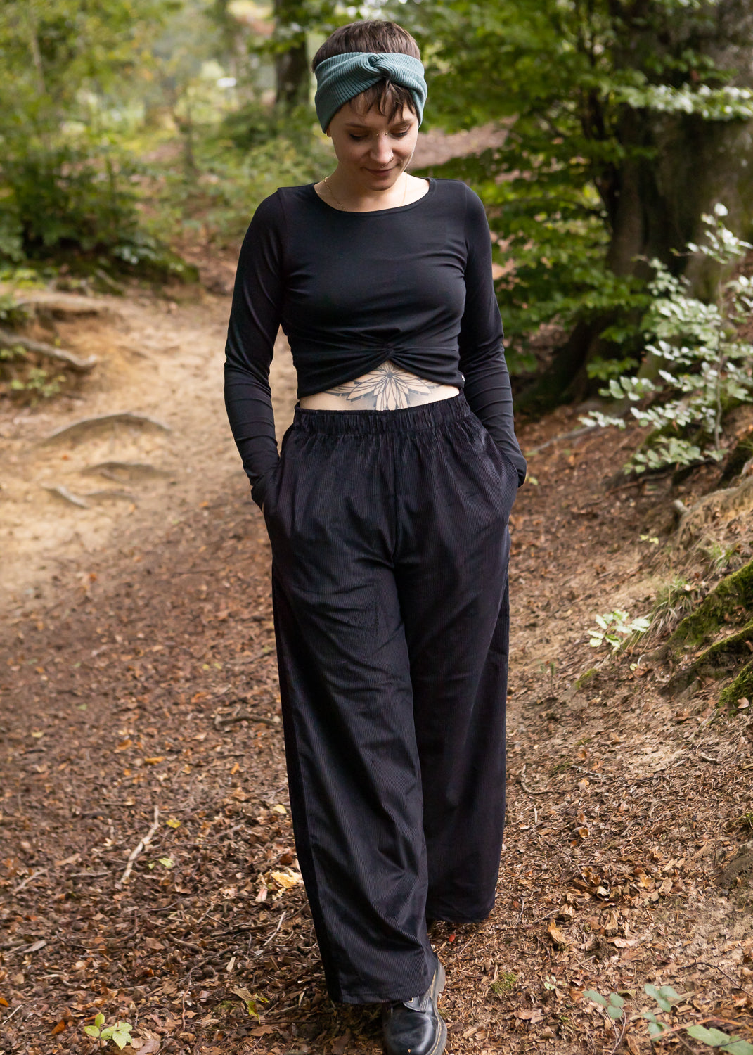 Melly trägt auf dem Foto 'Marlene' Größe M, Cord schwarz und 'Clara' Größe M, Rippjersey schwarz