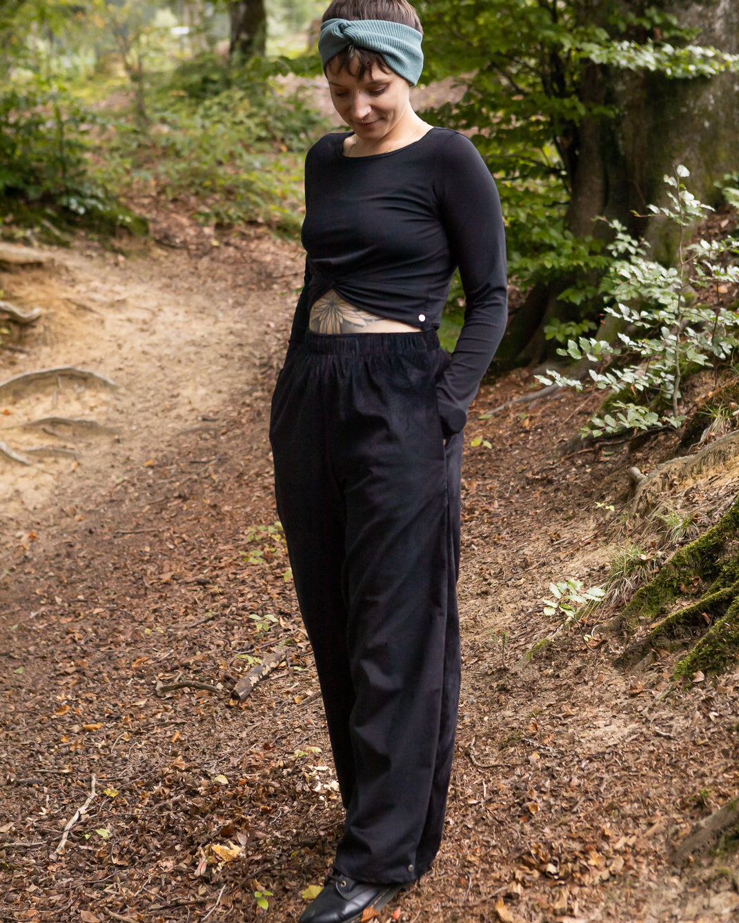 Melly trägt auf dem Foto 'Marlene' Größe M, Cord schwarz und 'Clara' Größe M, Rippjersey schwarz