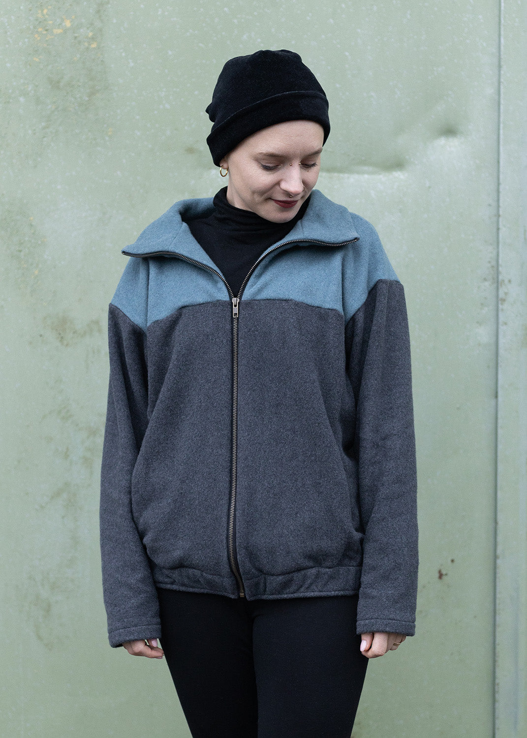 Melly trägt auf dem Foto 'Zoe' Größe M, Fleece rauchblau und dunkelgrau