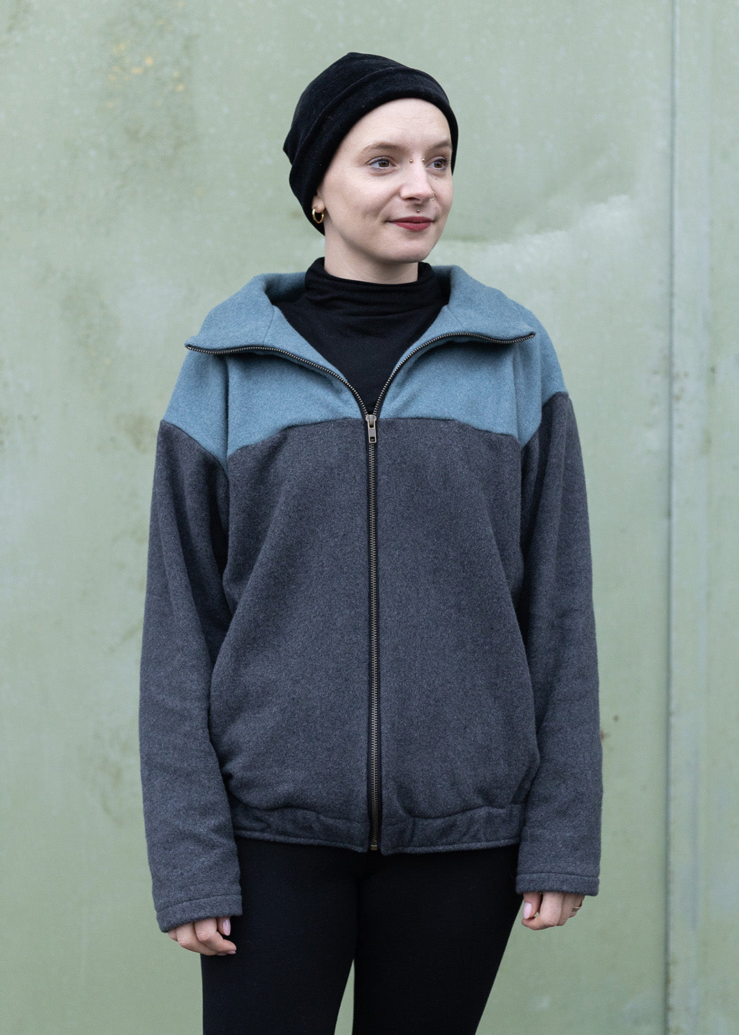 Melly trägt auf dem Foto 'Zoe' Größe M, Fleece rauchblau und dunkelgrau