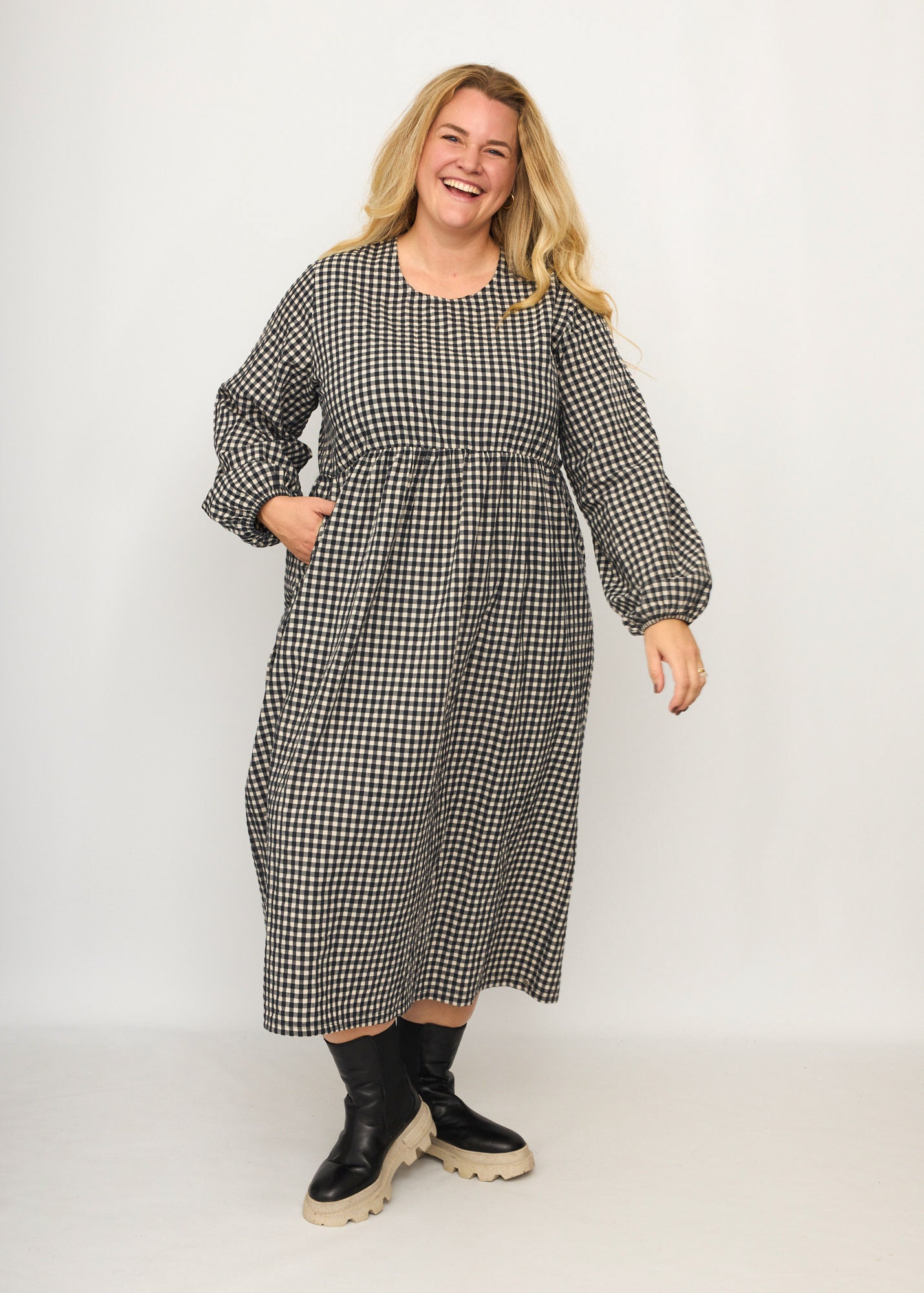 Nina trägt auf dem Foto 'Belinda', Ballonärmel, hohe Taille 5cm weiter unten, Größe 4XL +14 cm am Saum, Seersucker schwarz-creme