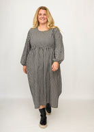 Nina trägt auf dem Foto 'Belinda', Ballonärmel, hohe Taille 5cm weiter unten, Größe 4XL +14 cm am Saum, Seersucker schwarz-creme