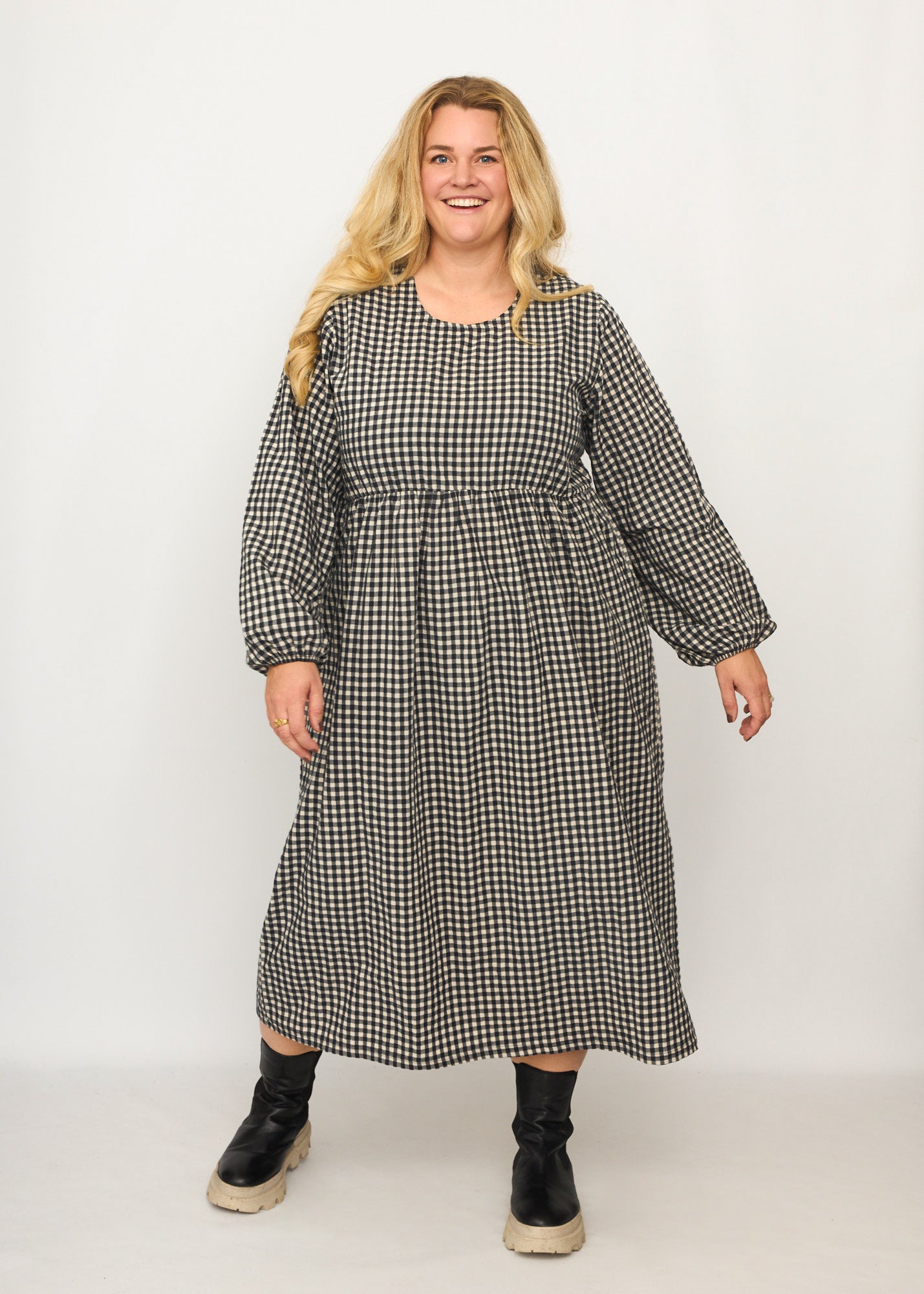 Nina trägt auf dem Foto 'Belinda', Ballonärmel, hohe Taille 5cm weiter unten, Größe 4XL +14 cm am Saum, Seersucker schwarz-creme