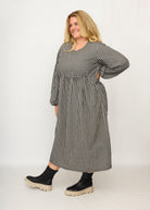 Nina trägt auf dem Foto 'Belinda', Ballonärmel, hohe Taille 5cm weiter unten, Größe 4XL +14 cm am Saum, Seersucker schwarz-creme